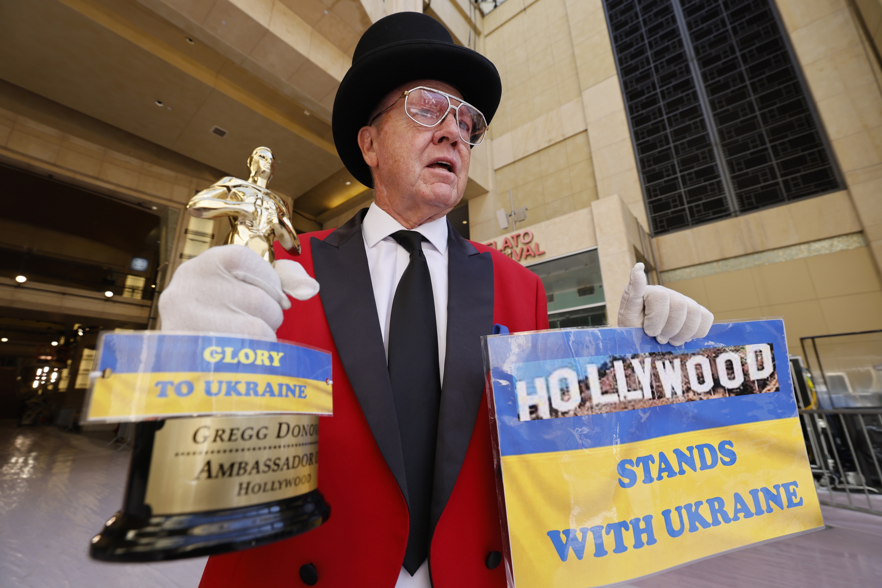 Gregg Donovan sostiene una rplica de un Oscar con un mensaje de apoyo a Ucrania.