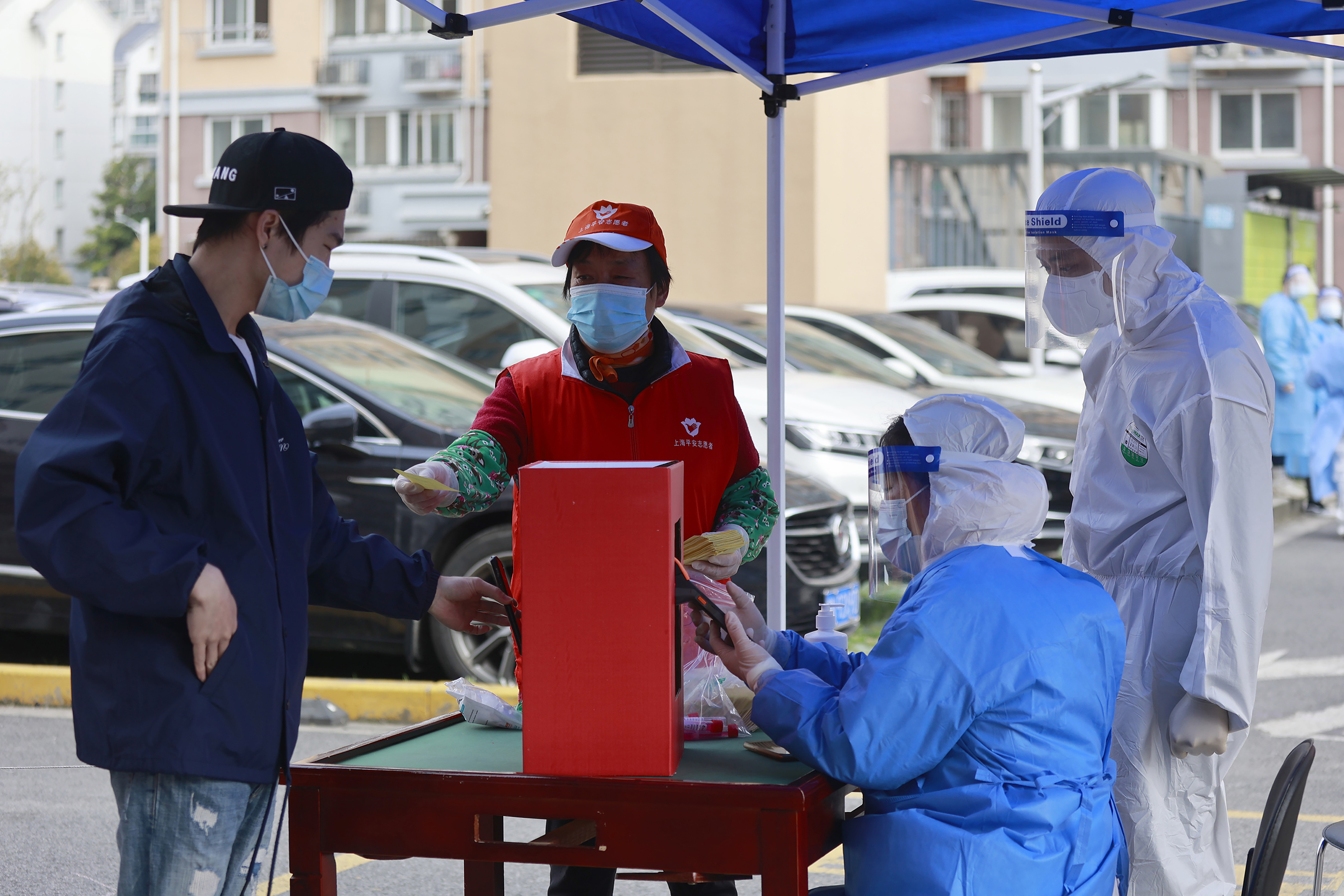 Un residente se prepara para hacerse una prueba de Covid-19 en una comunidad residencial bajo encierro en Shanghi.