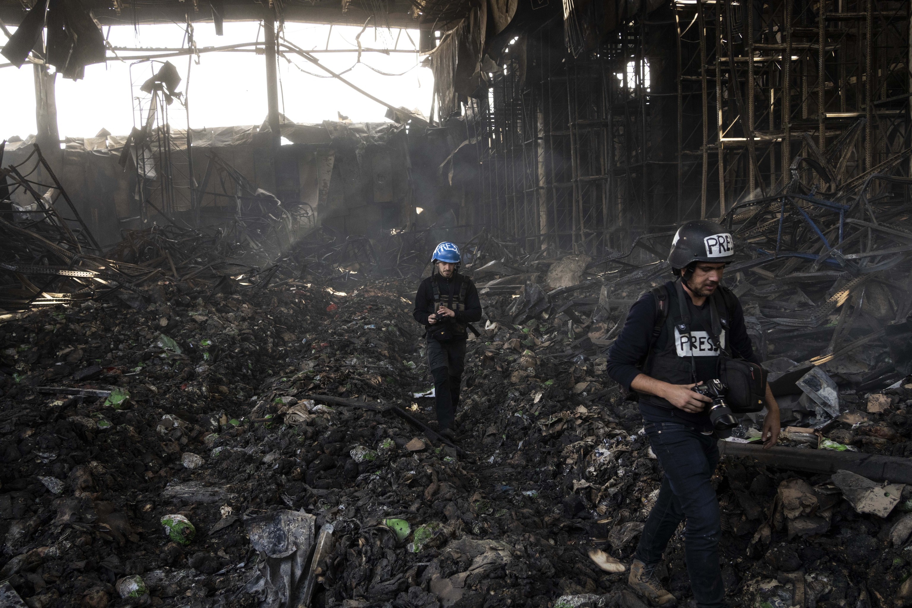 Periodistas en un almacn destruido por bombas rusas cerca de Kiev.