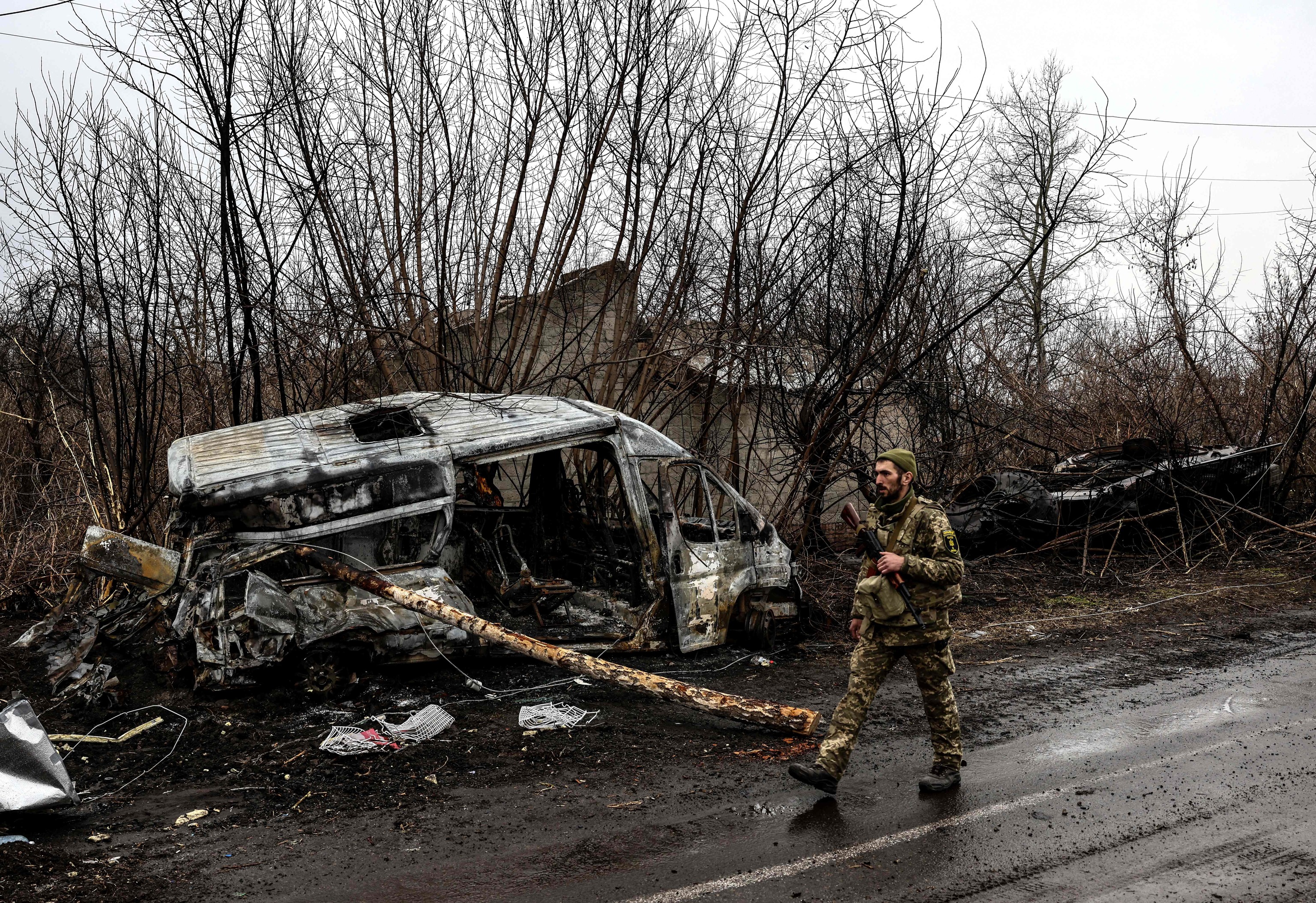 Un soldado pasa por delante de una furgoneta quemada, cerca de Kiev.