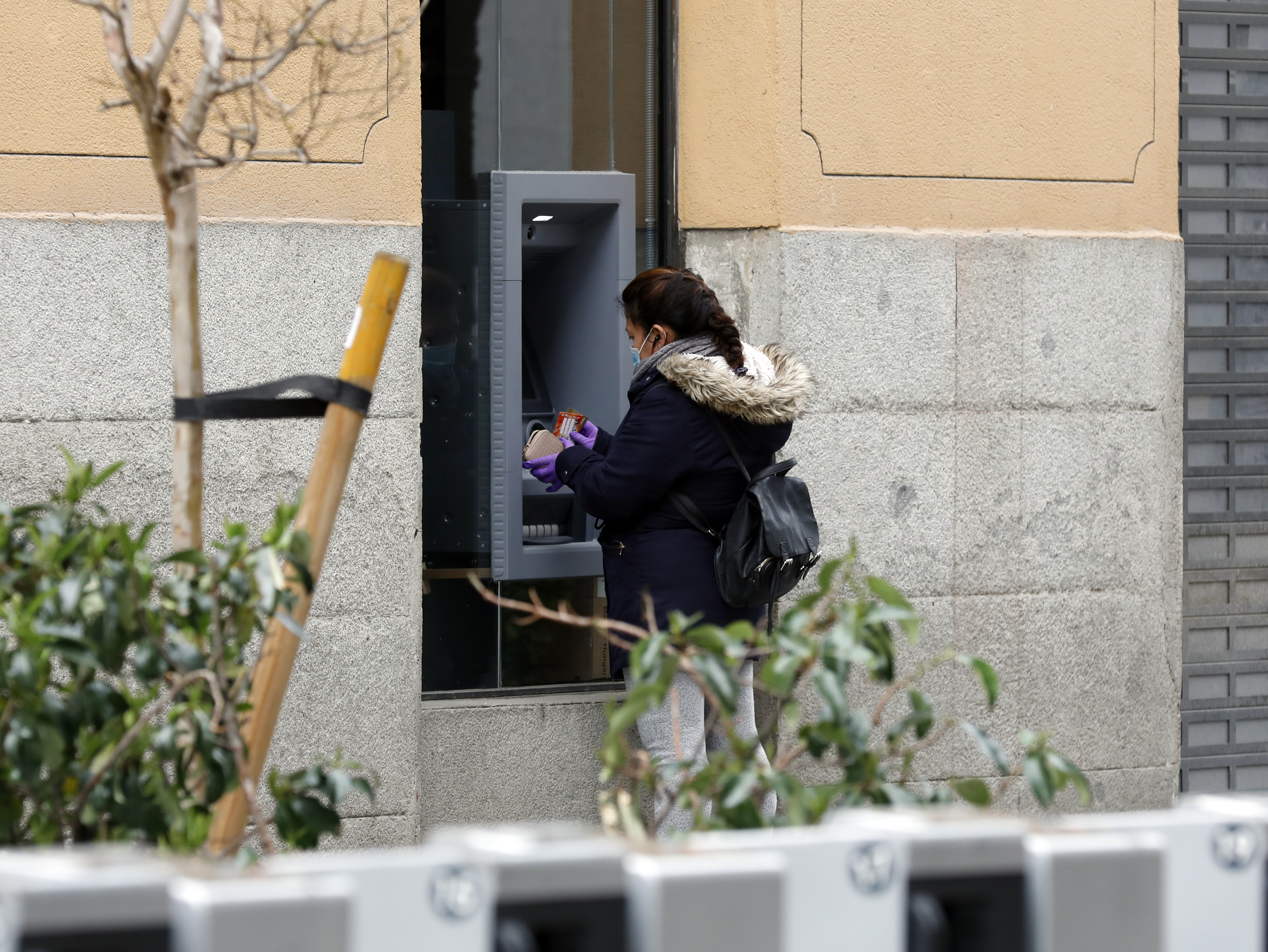 Una mujer saca dinero de un cajero en Madrid