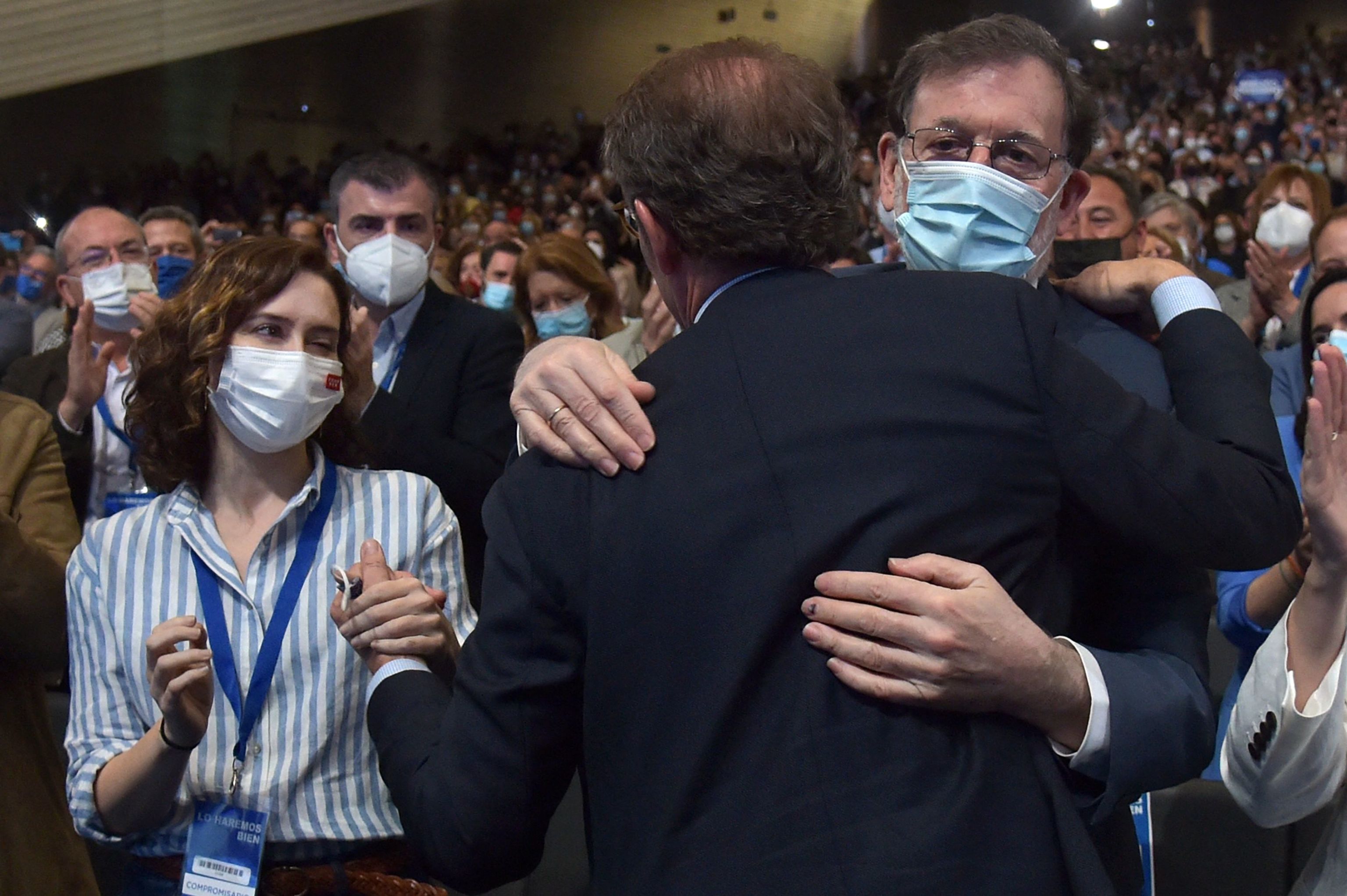 Alberto Núñez Feijóo abraza a Mariano Rajoy en presencia de Isabel Díaz Ayuso.