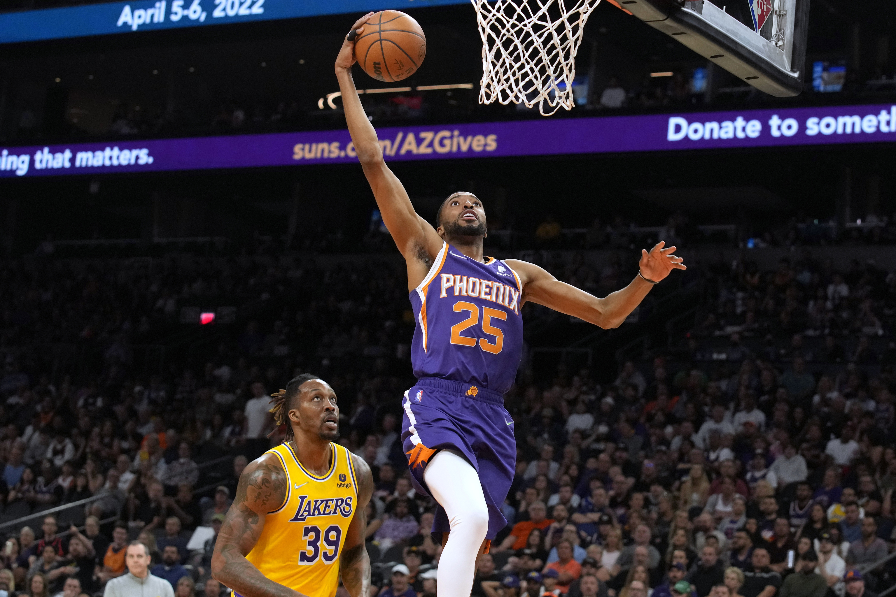 El alero de los Phoenix Suns, Mikal Bridges, supera al pvot de Los ngeles Lakers, Dwight Howard (39), durante la segunda mitad de un partido de baloncesto de la NBA, el martes 5 de abril de 2022, en Phoenix. Los Suns ganaron 121-110.