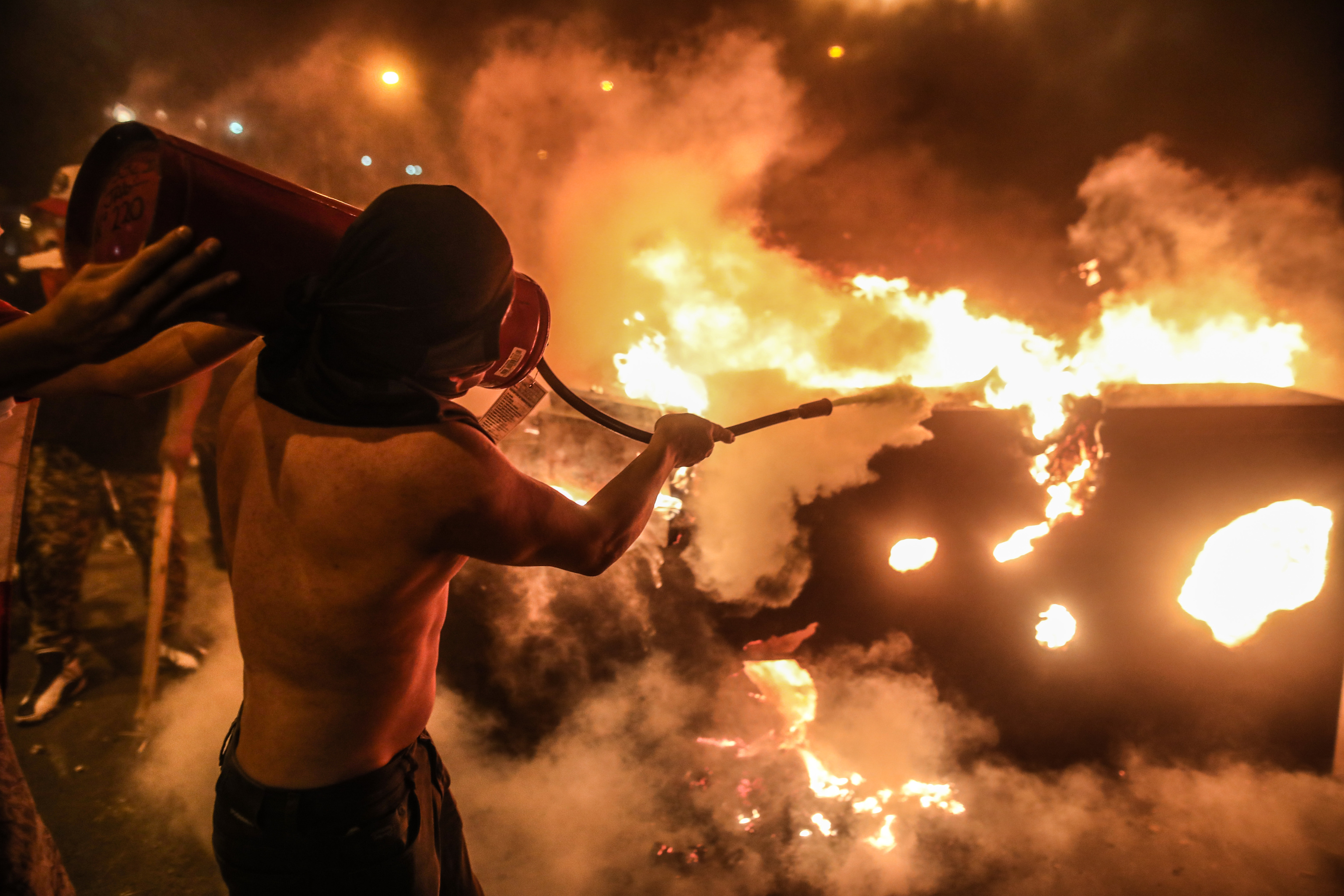 Un manifestante trata de apagar el fuego durante una manifestación, en Lima.