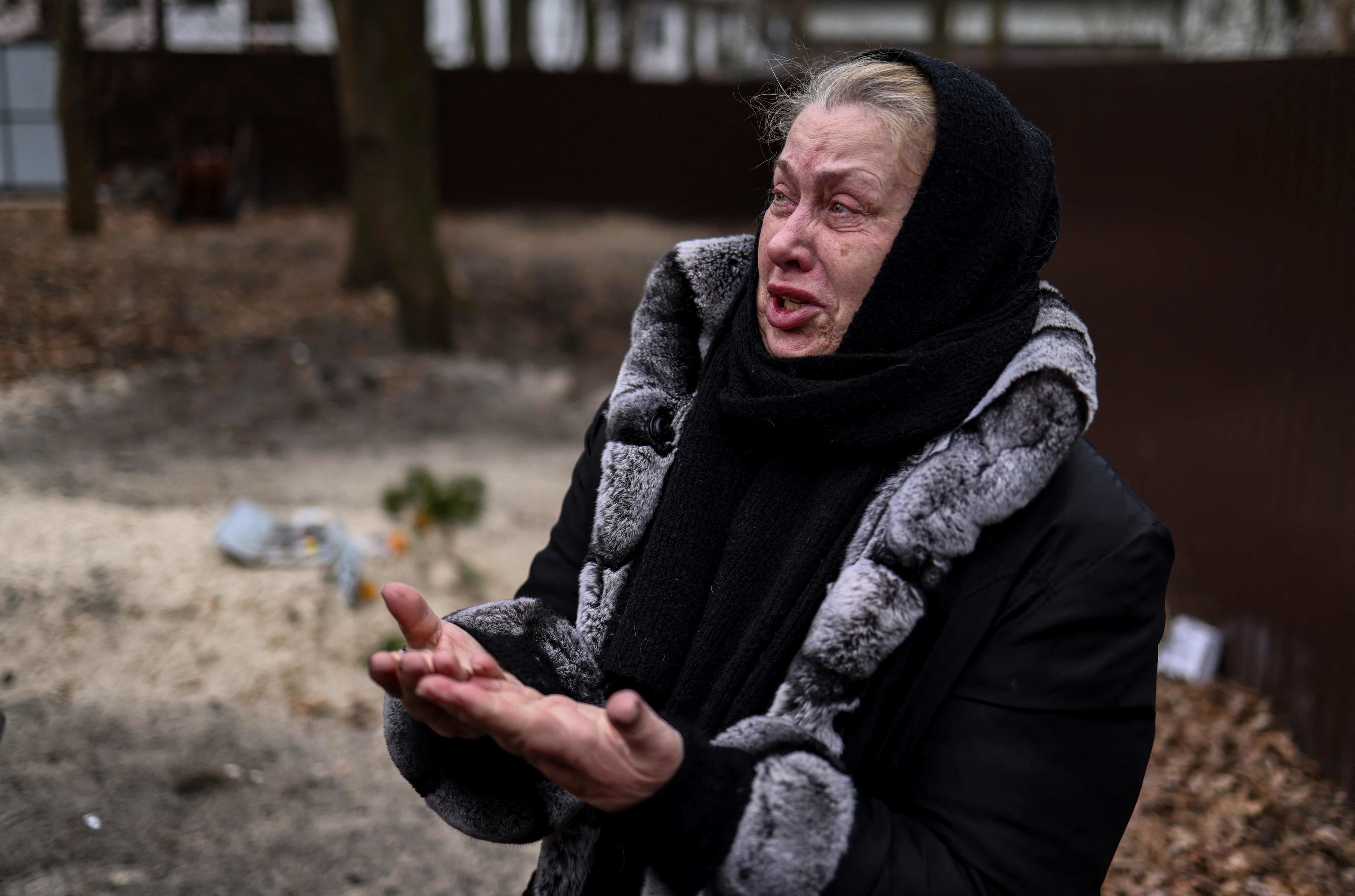 Una mujer llora la muerte de su hijo, enterrado en el jardín de su casa en Bucha.