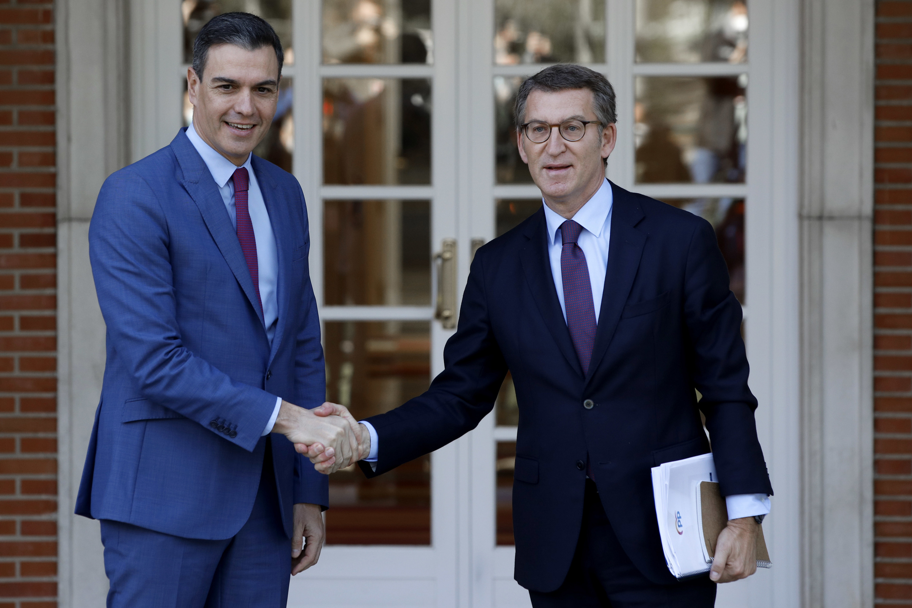 Pedro Sánchez y Alberto Núñez Feijóo se saludan antes de su reunión en La Moncloa.