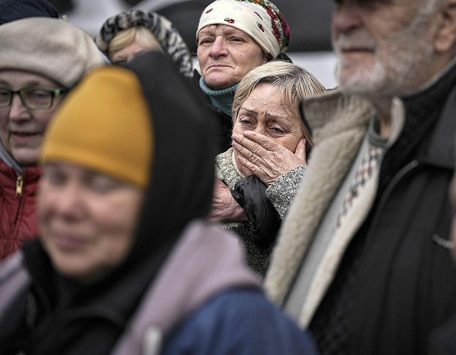 Una mujer llora junto a otros residentes, en Bucha.