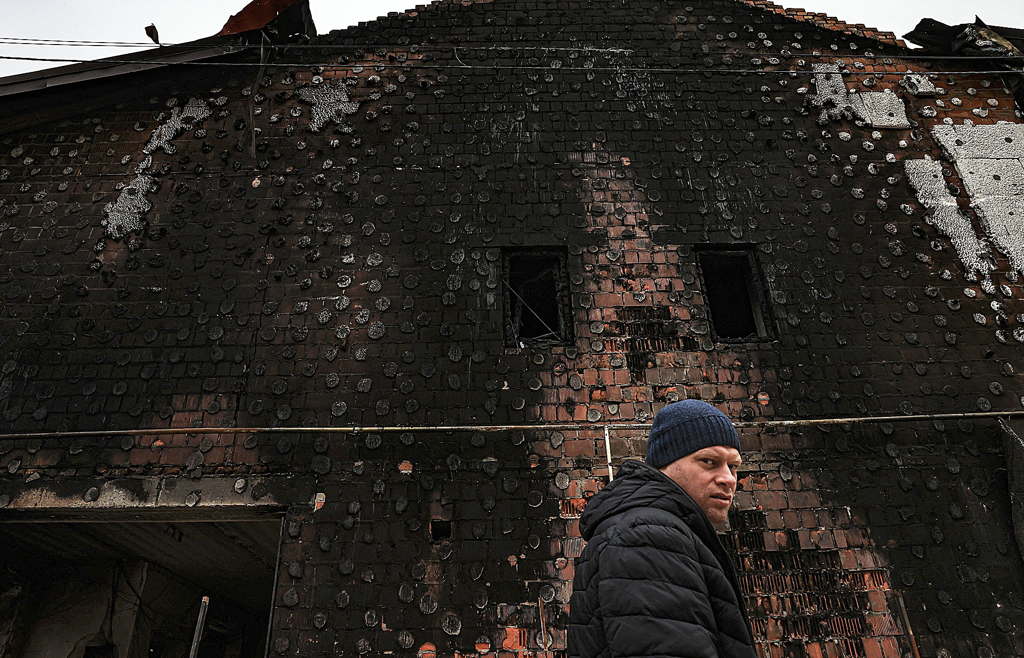 Un hombre limpia los escombros en un edificio destruido, en Hostomel.
