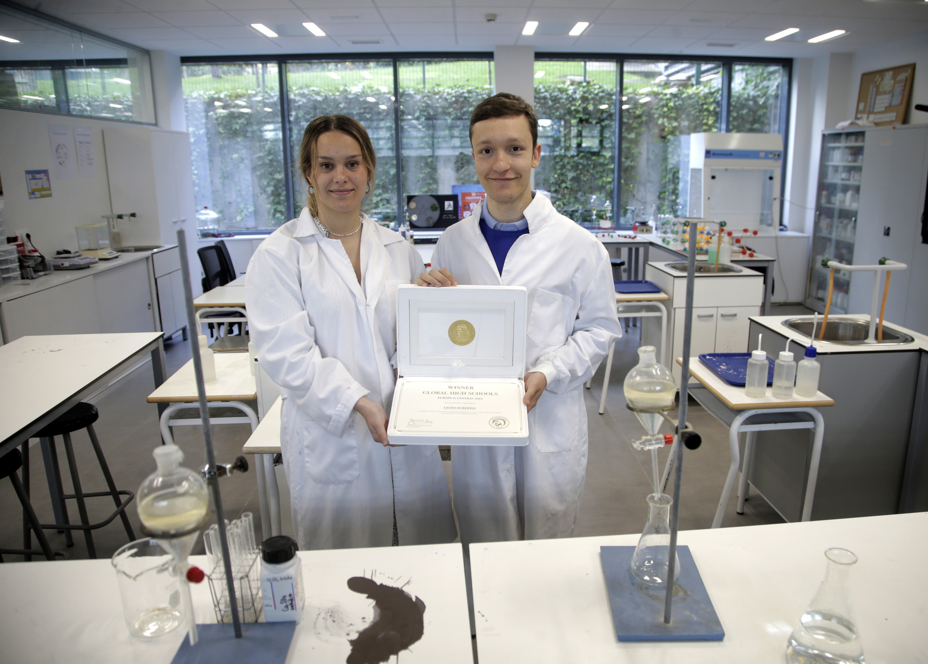Los estudiantes Lucía Munnecke y Pablo Luengo, en el laboratorio del Liceo Europeo con el premio mundial de sostenibilidad recibido en Dubái.