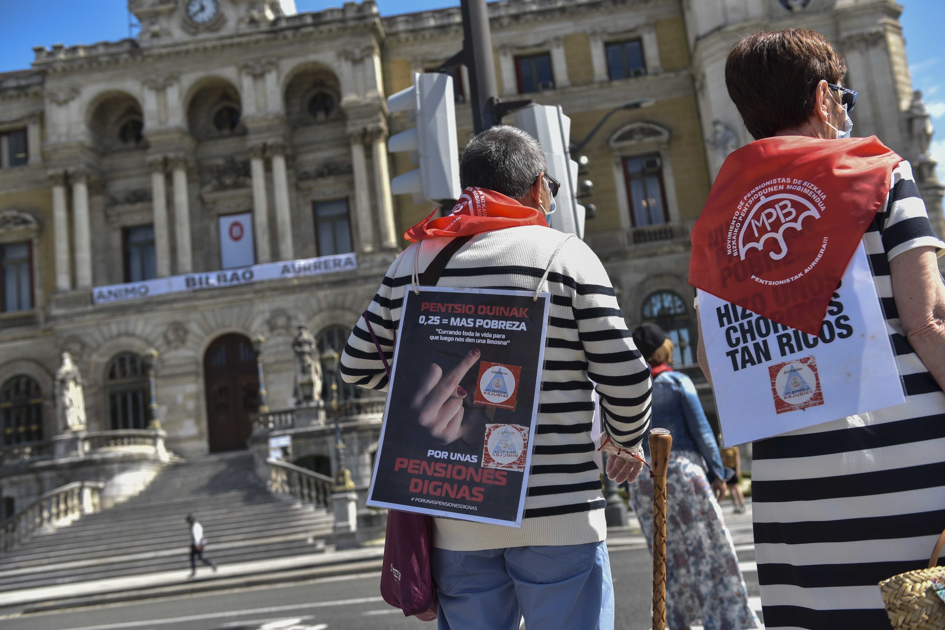 Dos pensionistas portan carteles reivindicativos tras participar en una de las concentraciones semanales frente al Ayuntamiento de Bilbao.