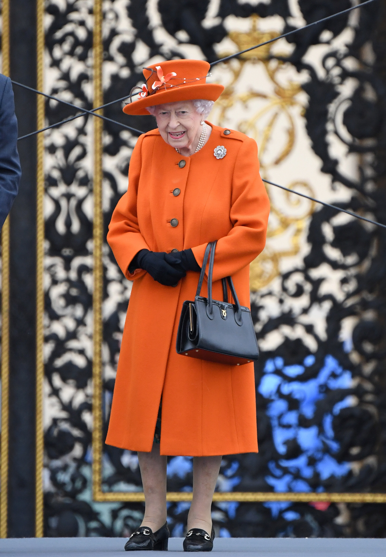 La reina de Inglaterra, con sus caracterstico peinado, su bolso y un abrigo de color vivo.