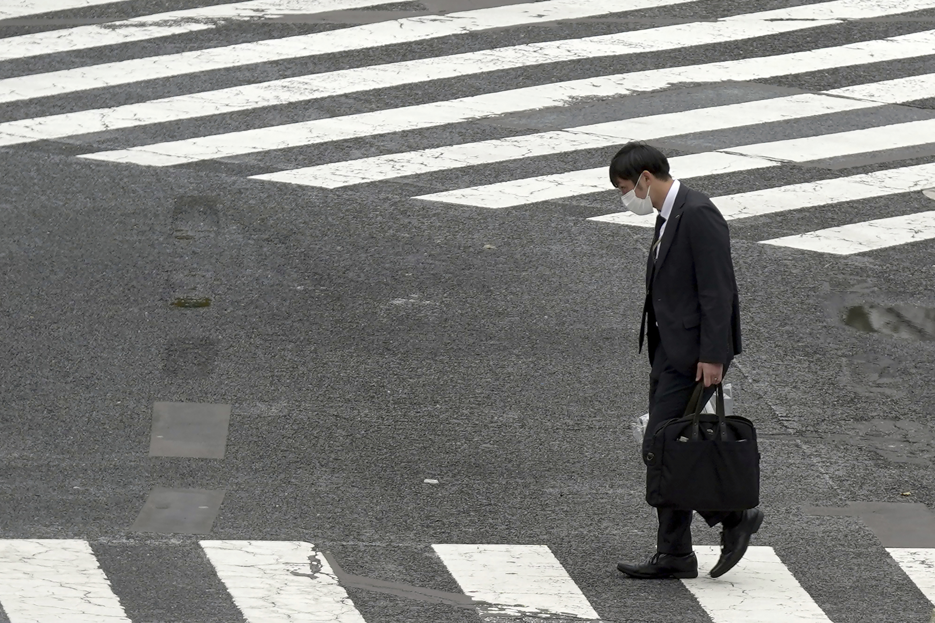 Un trabajador cruza un paso de cebra en Tokio.