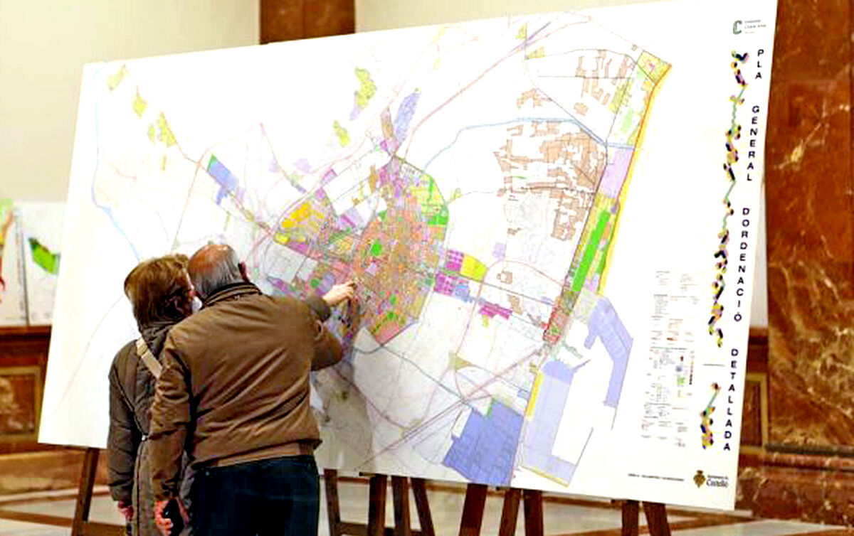 Dos ciudadanos consultan el mapa del Plan General de Castelln expuesto.