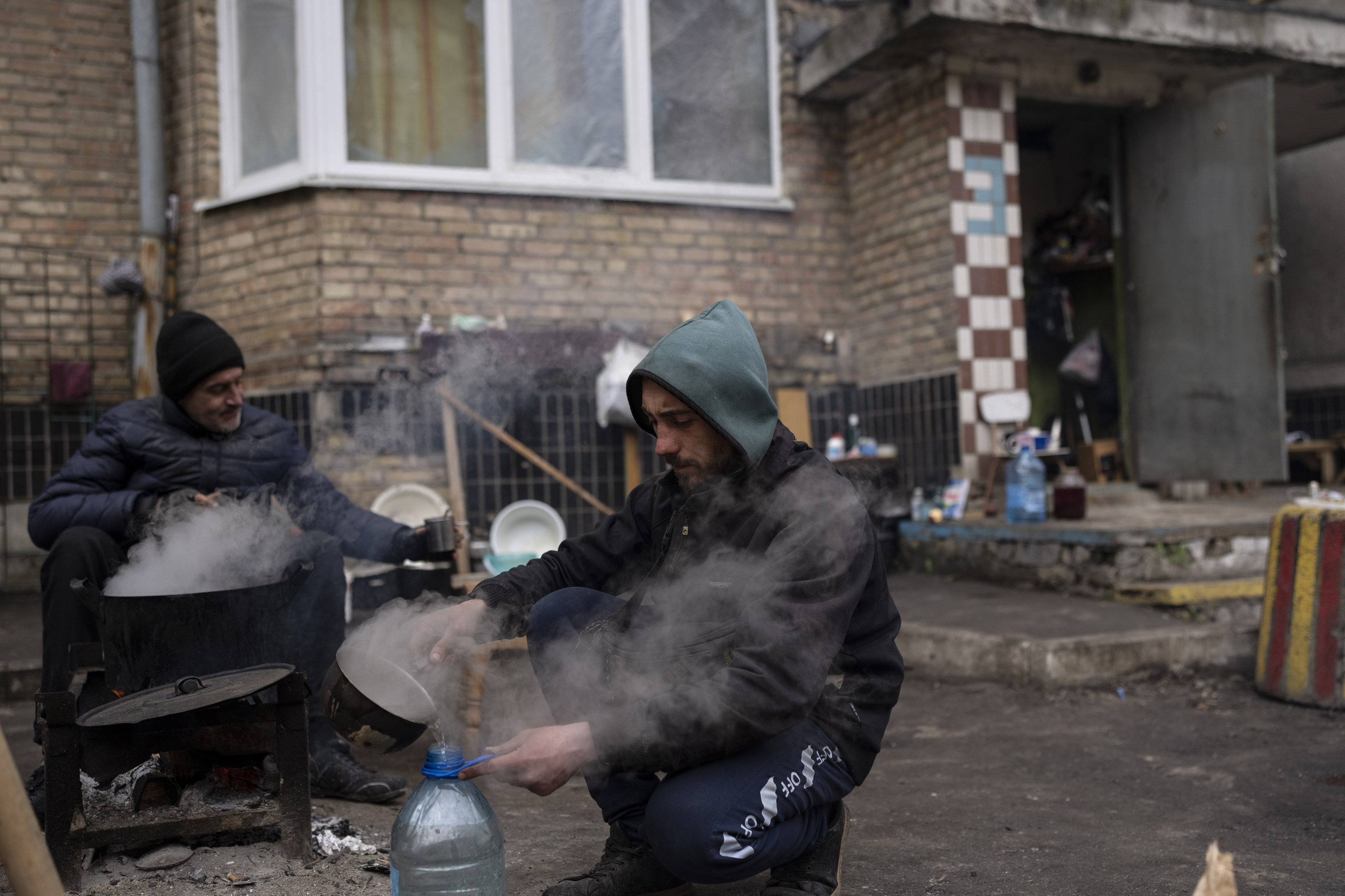 Zhenya Vanag, 32, prepares hot water to take a shower outside his house destroyed by Russian shelling in Irpin, on the outskirts of Kyiv, on Thursday, April 21, 2022. Citizens of Irpin are still without electricity, water and gas after since the Russian invasion began. (AP Photo/Petros  lt;HIT gt;Giannakouris lt;/HIT gt;)
