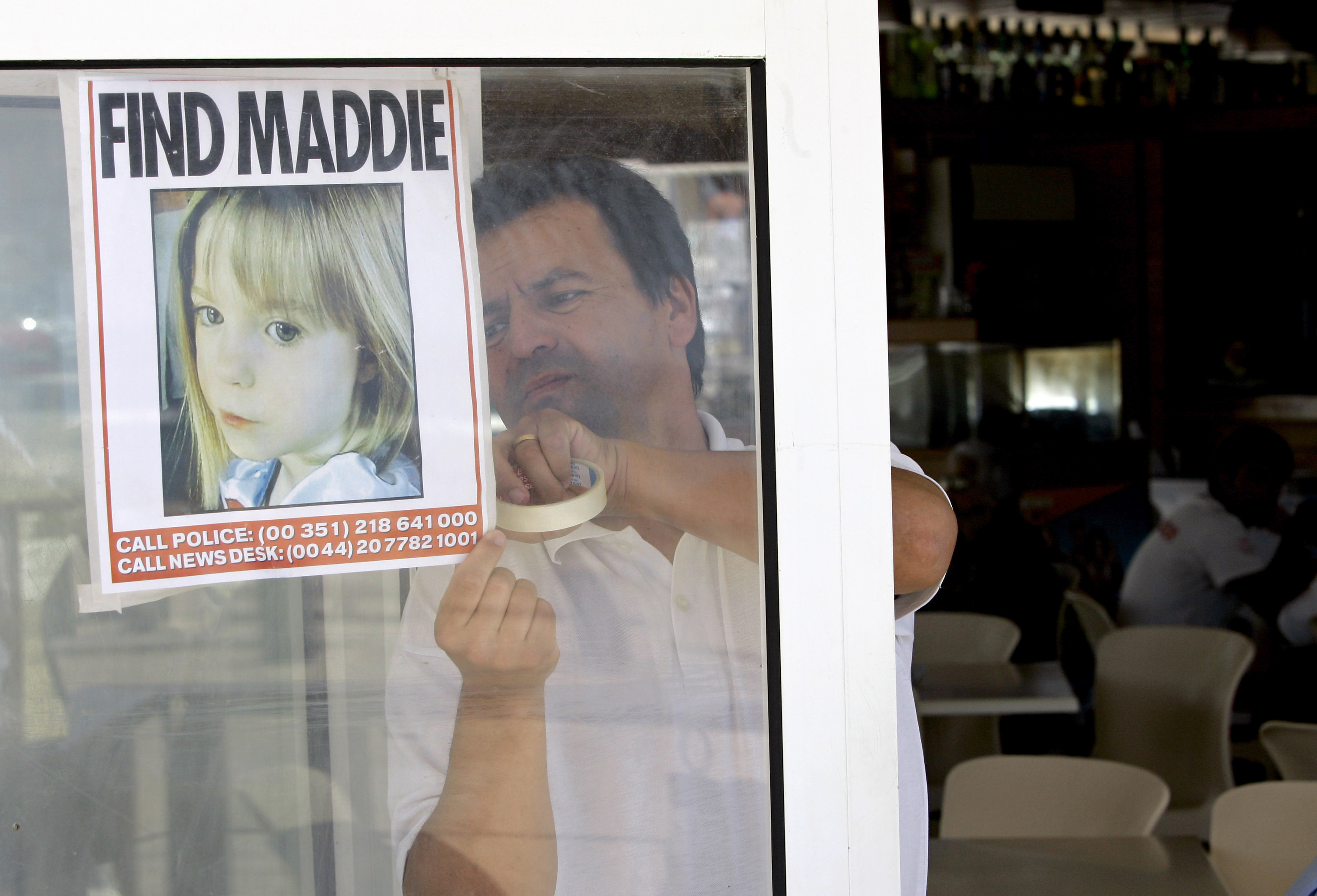 Un camarero cuelga una foto de la nia desaparecida de 3 aos Madeleine McCann en la ventana de un restaurante, el jueves 10 de mayo de 2007, en Praia da Luz, sur de Portugal.