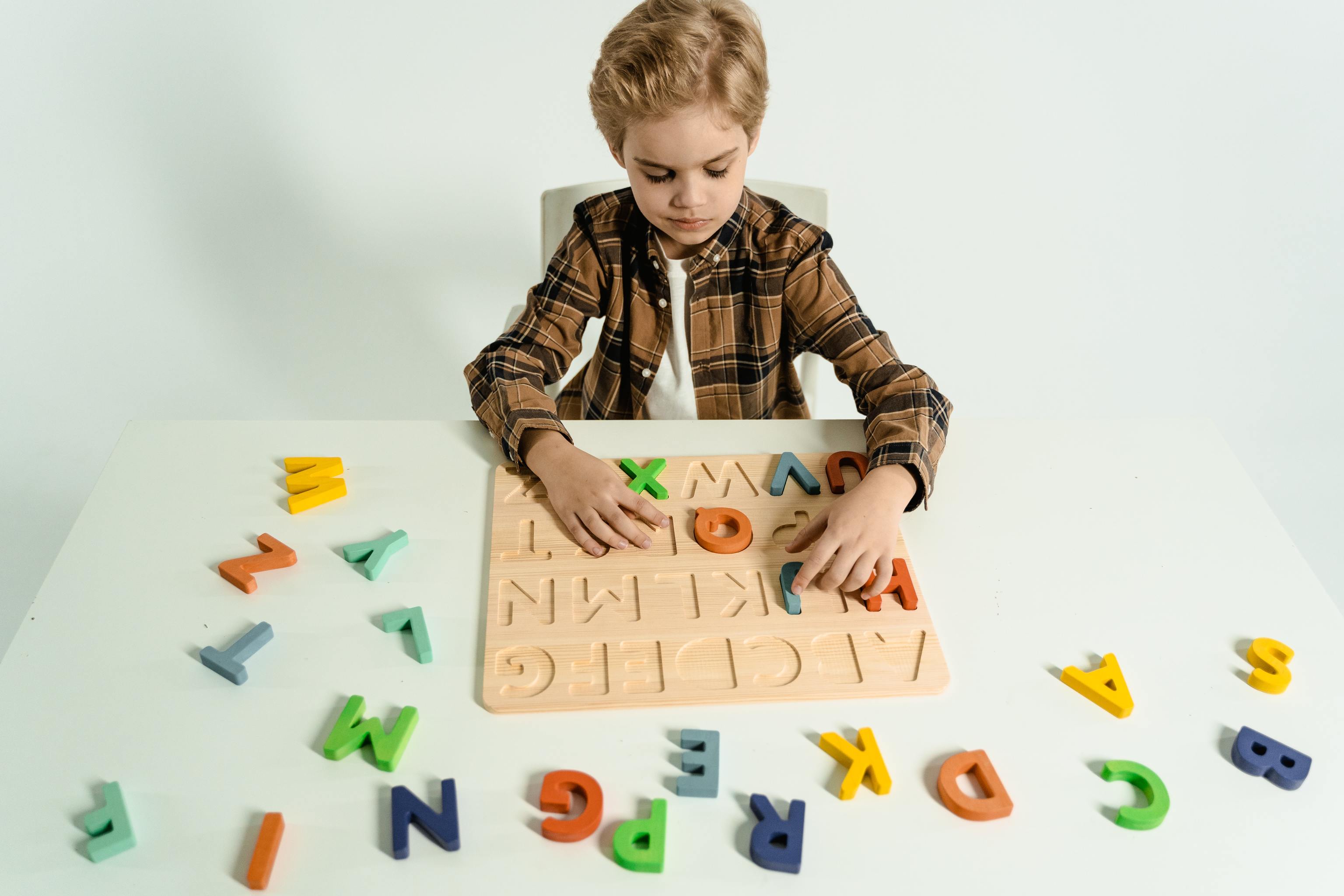 Un niño juega con un abecedario de letras de madera.