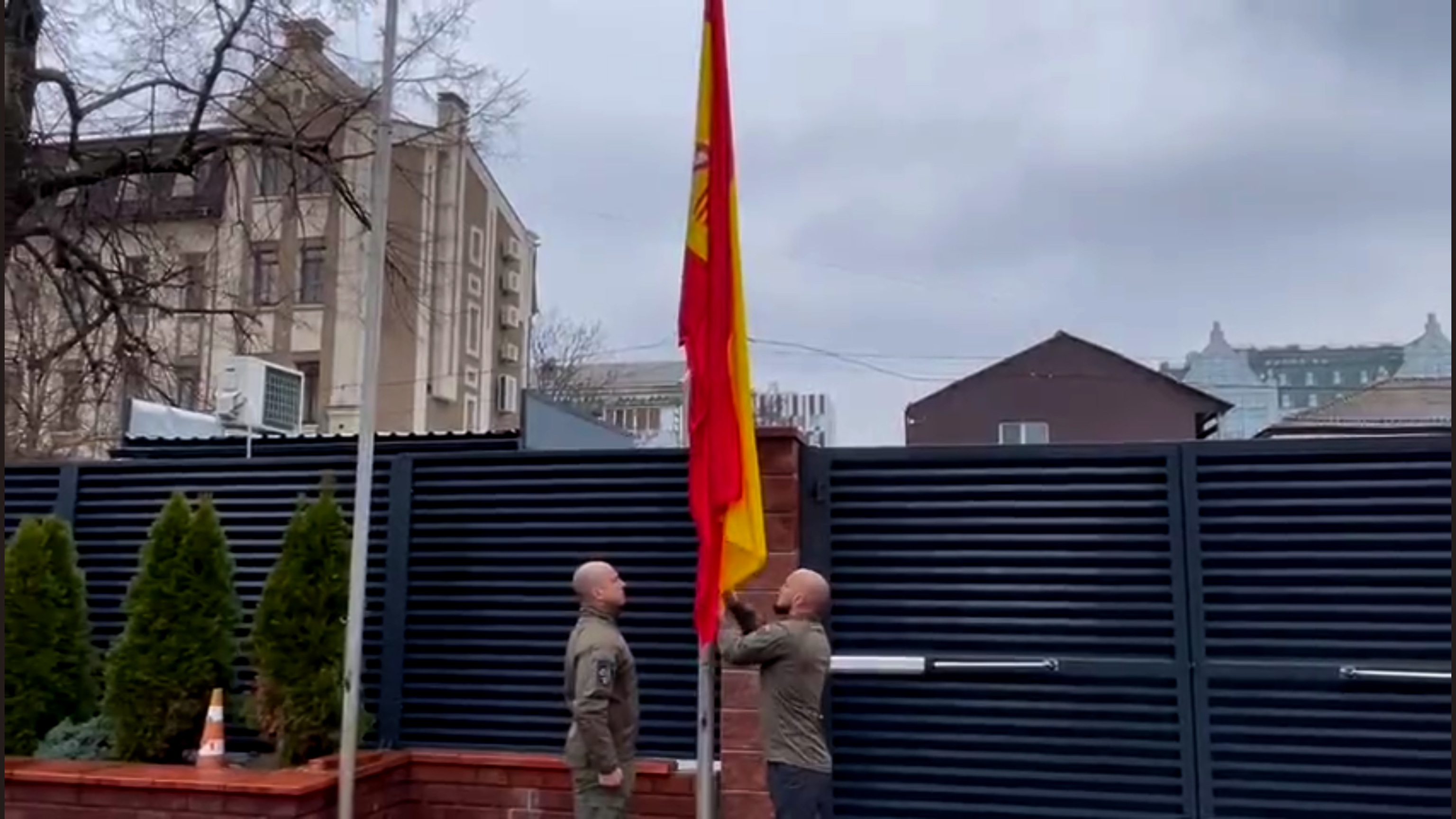 Dos agentes de los Geos izan la bandera en la embajada de Espaa en Kiev tras su reapertura.