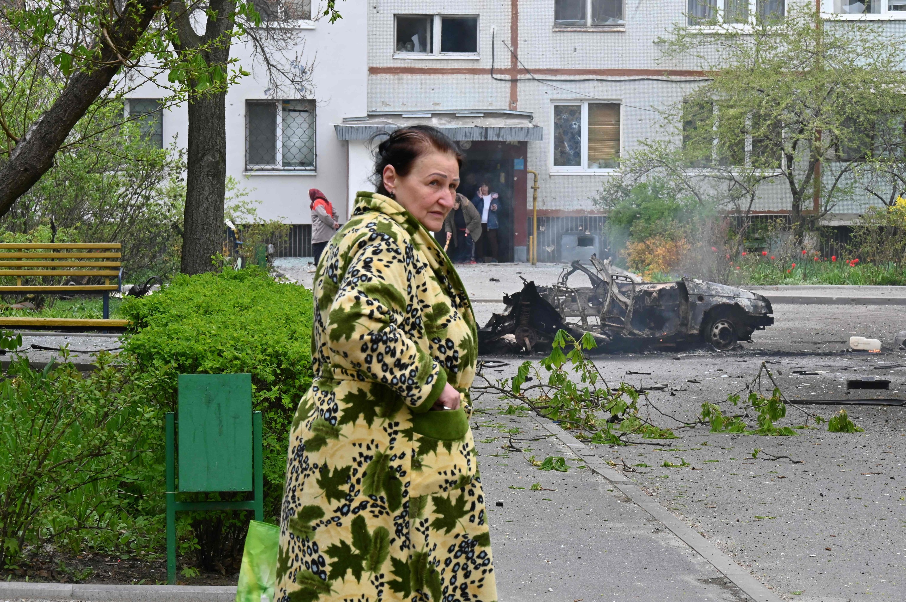 Una mujer pasa junto a un coche destruido, en Járkov.