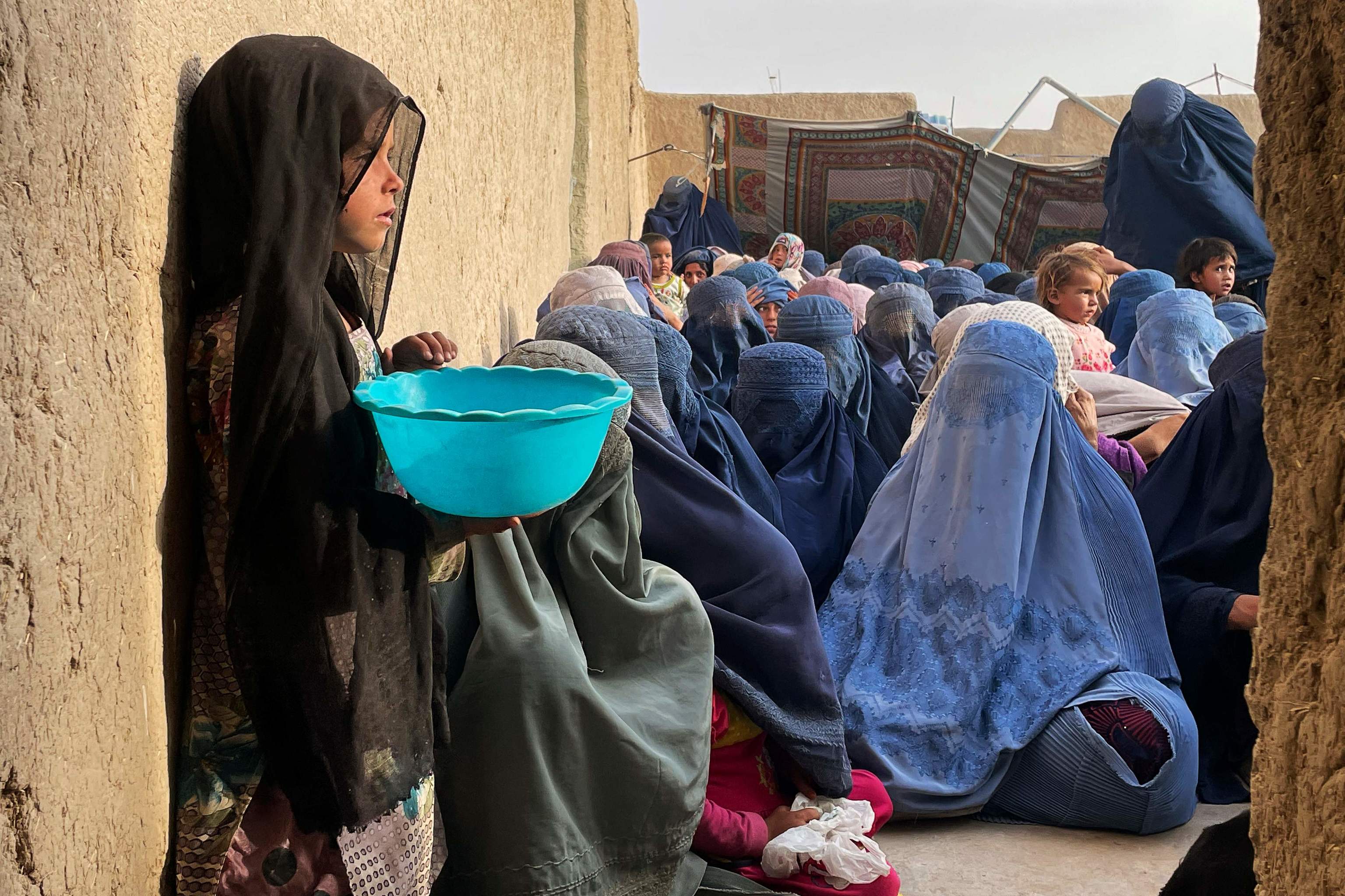 Mujeres y niños esperan una donación de comida, en Kandahar (Afganistán).