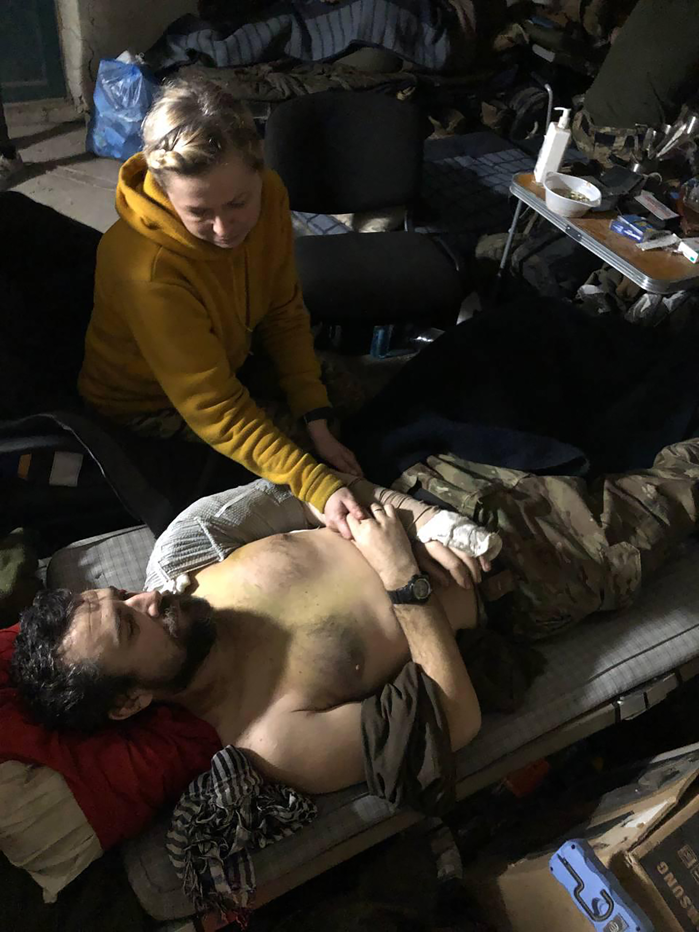 Una mujer consolando a un herido en el interior de la planta siderúrgica Azovstal, en Mariupol, al este de Ucrania.