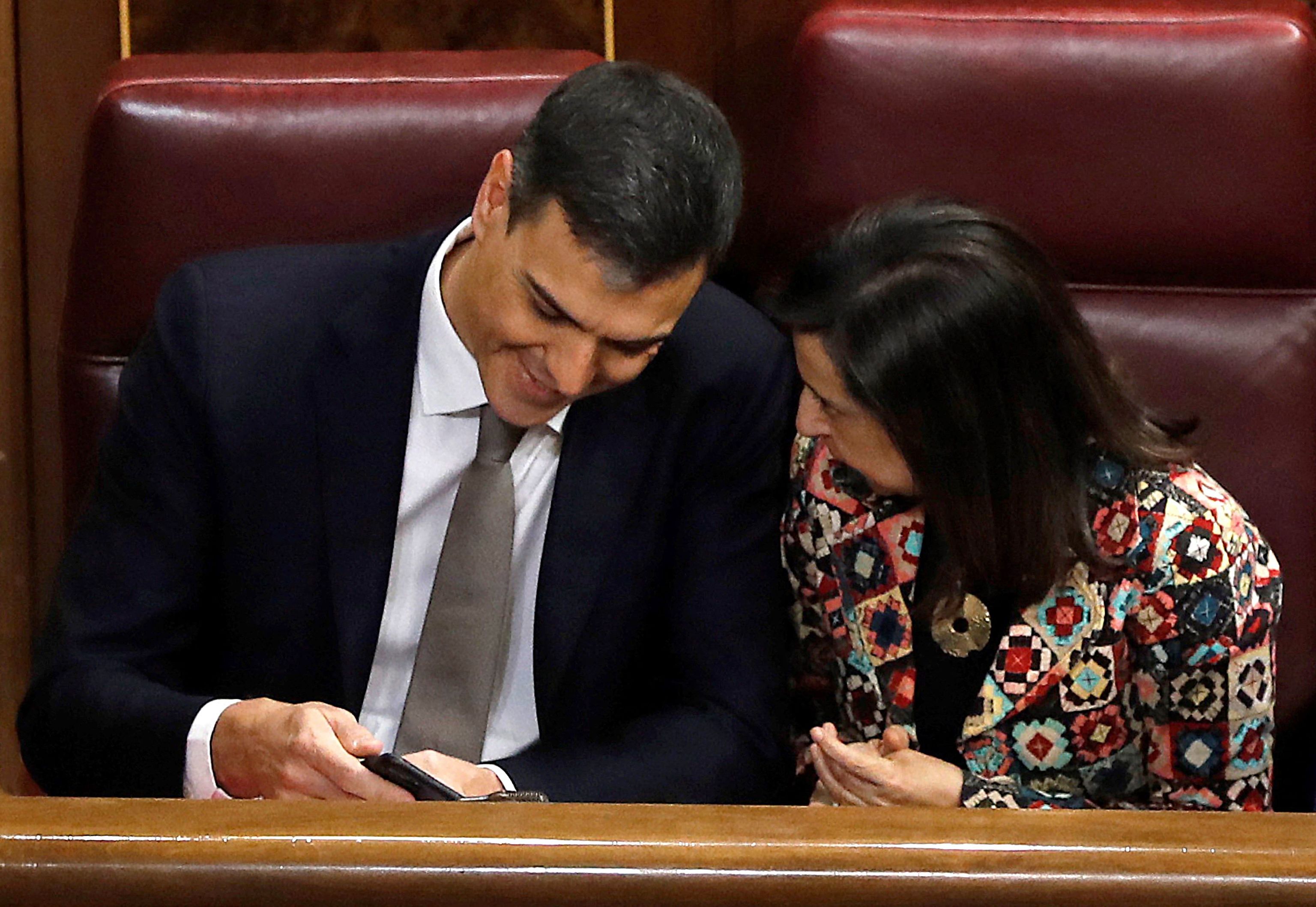 (FILES) In this file photo taken on May 31, 2018 then leader of the Spanish Socialist Party PSOE, Pedro  lt;HIT gt;Sanchez lt;/HIT gt; (L) shows his mobile to socialist MP Margarita Robles during a debate on a no-confidence motion at the Lower House of the Spanish Parliament in Madrid. - Spain said on May 2, 2022 that the mobile phones of Prime Minister Pedro  lt;HIT gt;Sanchez lt;/HIT gt; and Defence Minister Margarita Robles were tapped using Pegasus spyware in an "illicit and external" intervention. (Photo by Juan Carlos Hidalgo / POOL / AFP)