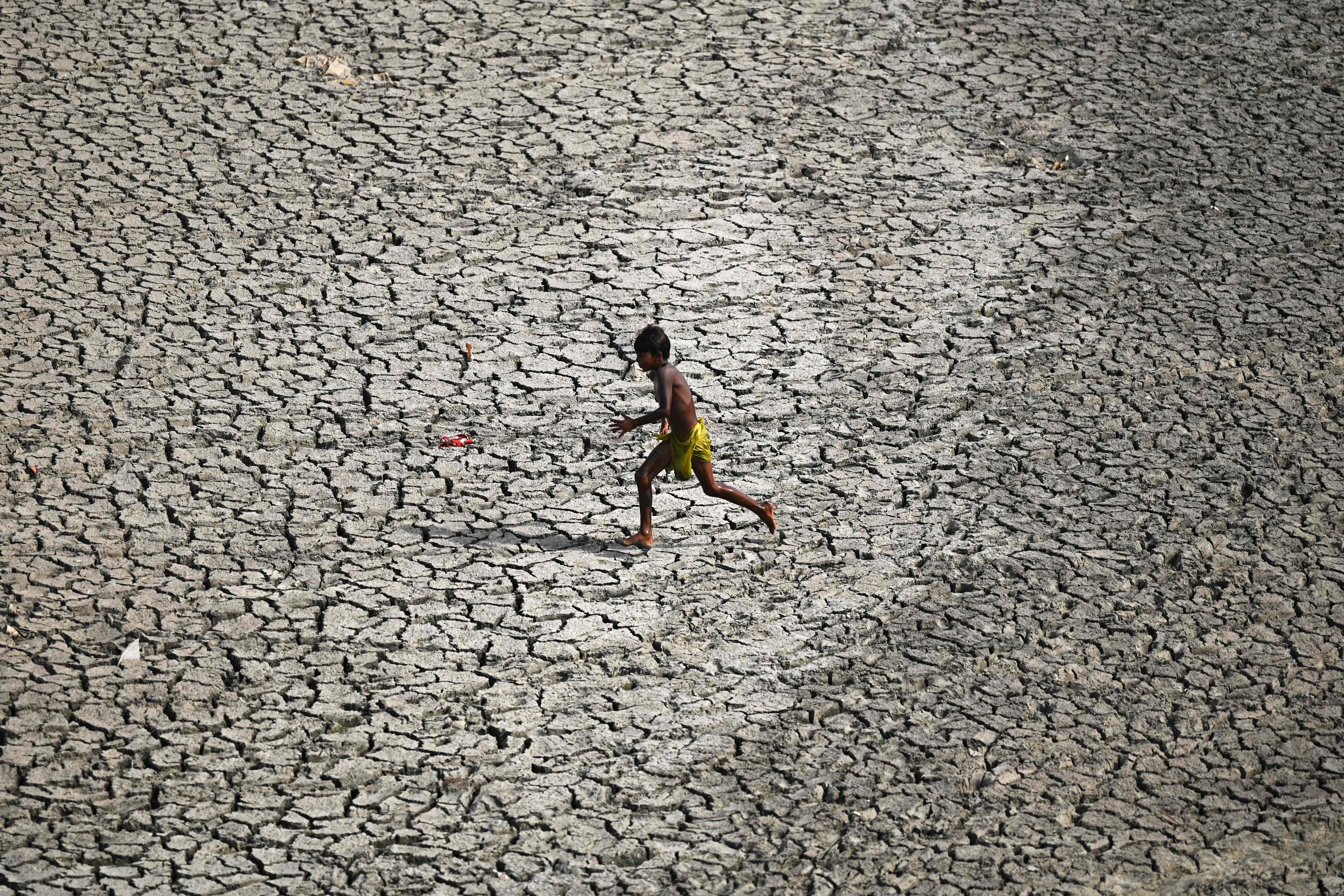 Un  nio camina por el lecho reseco del ro Yamuna, en Nueva Delhi.