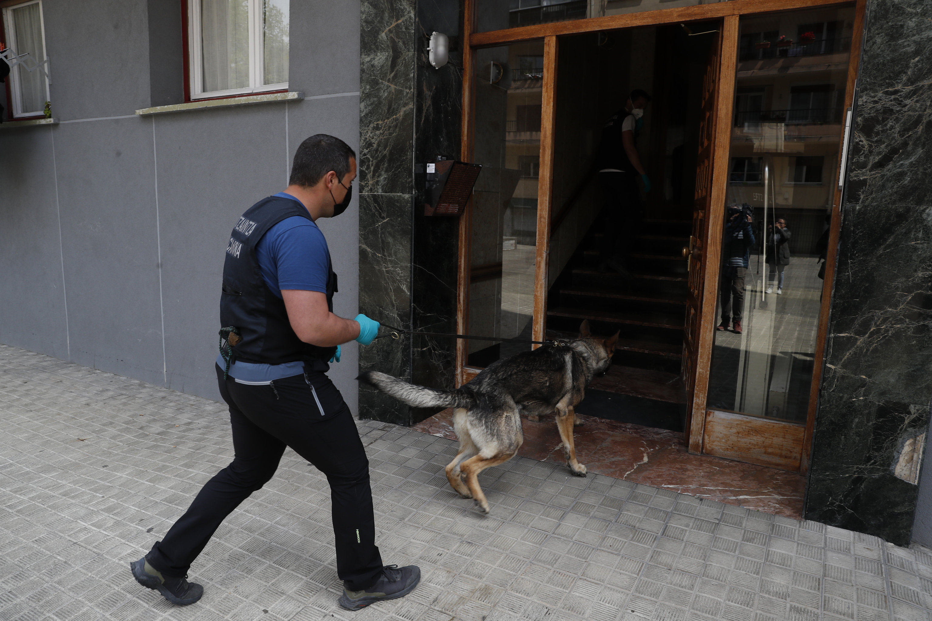 Un ertzaina de la unidad canina accede al piso en el que resida el sospechoso de los crmenes en Bilbao.