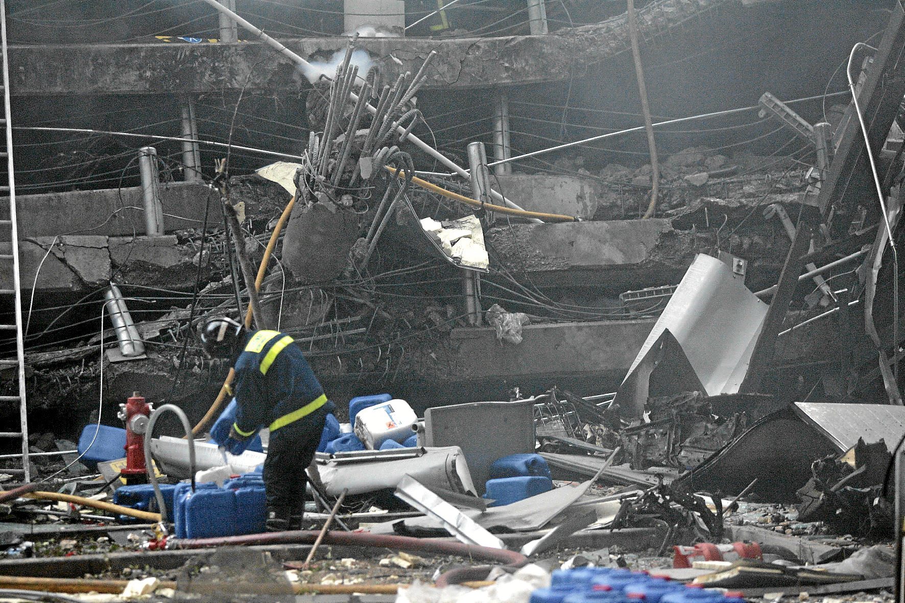 Un bombero trabaja entre los escombros del parking de la terminal T-4 tras el atentado de ETA en 2006.