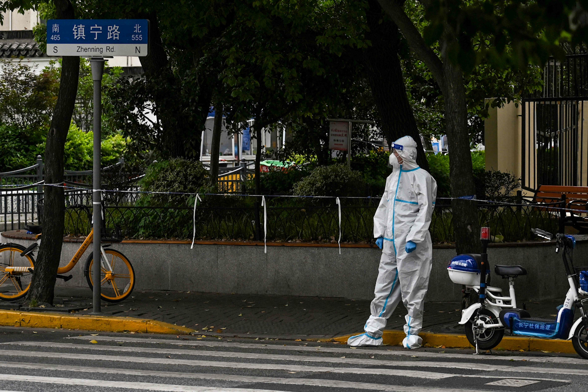 Una persona con un EPI en una calle de la confinada Shanghai.