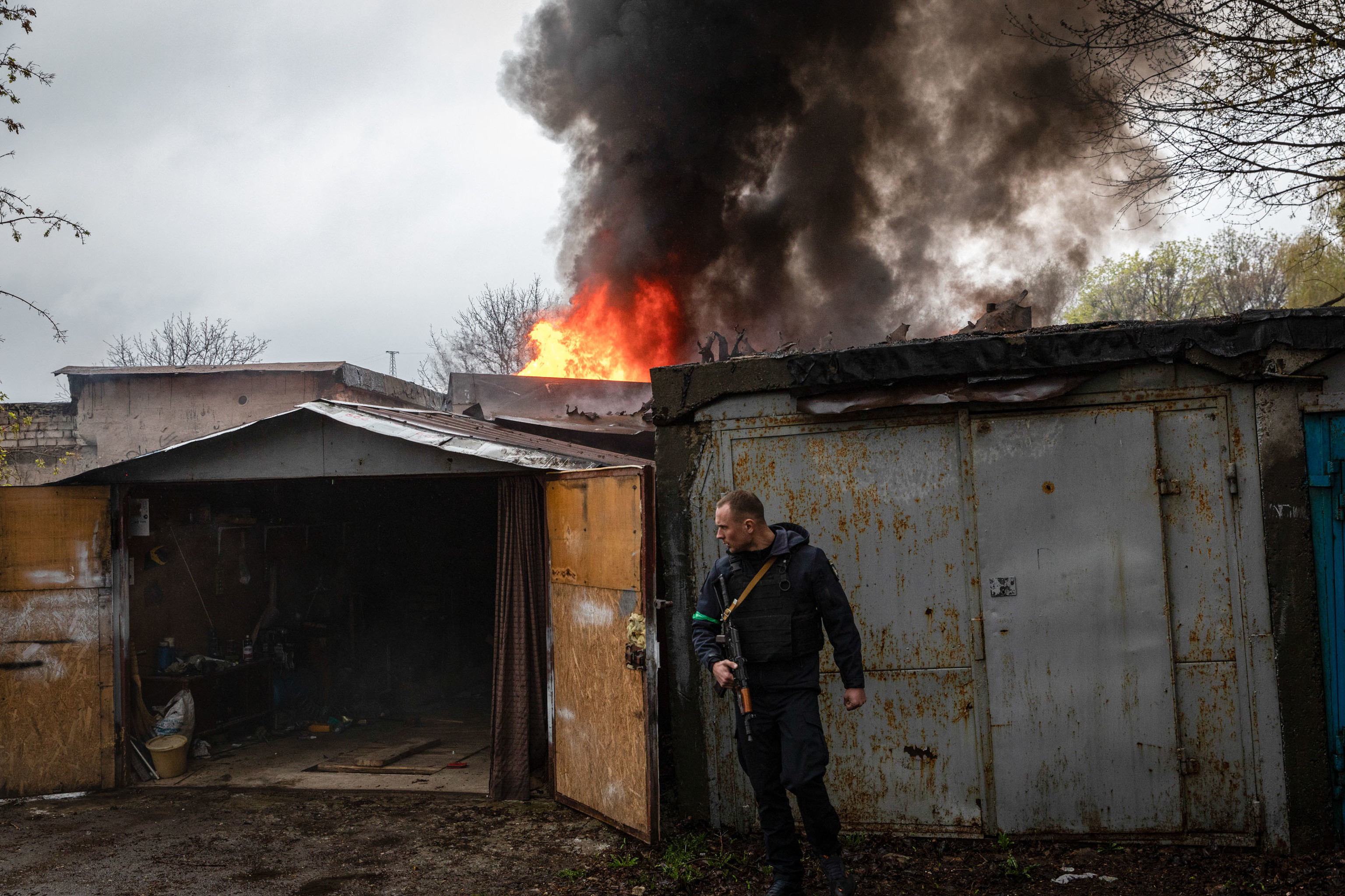 Ukrainian soldiers behind a bombed house in Kharkov.
