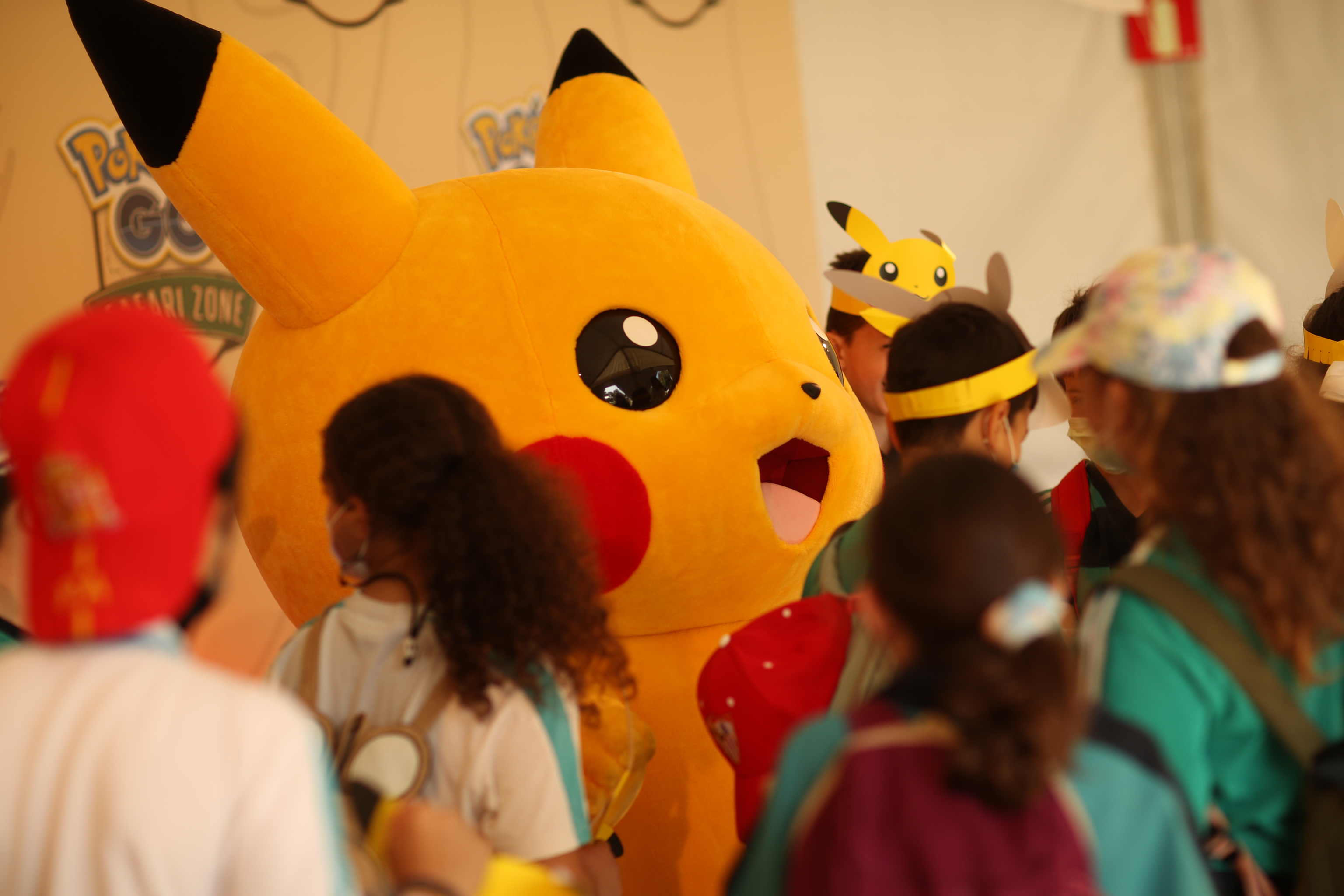 Video game fans next to a figure of Pikachu, one of Poco