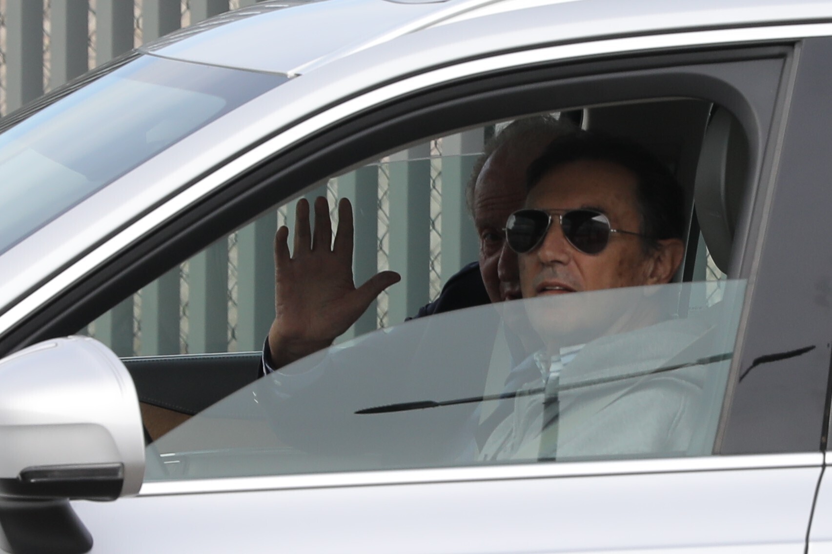 Don Juan Carlos saluda desde el coche de Pedro Campos.