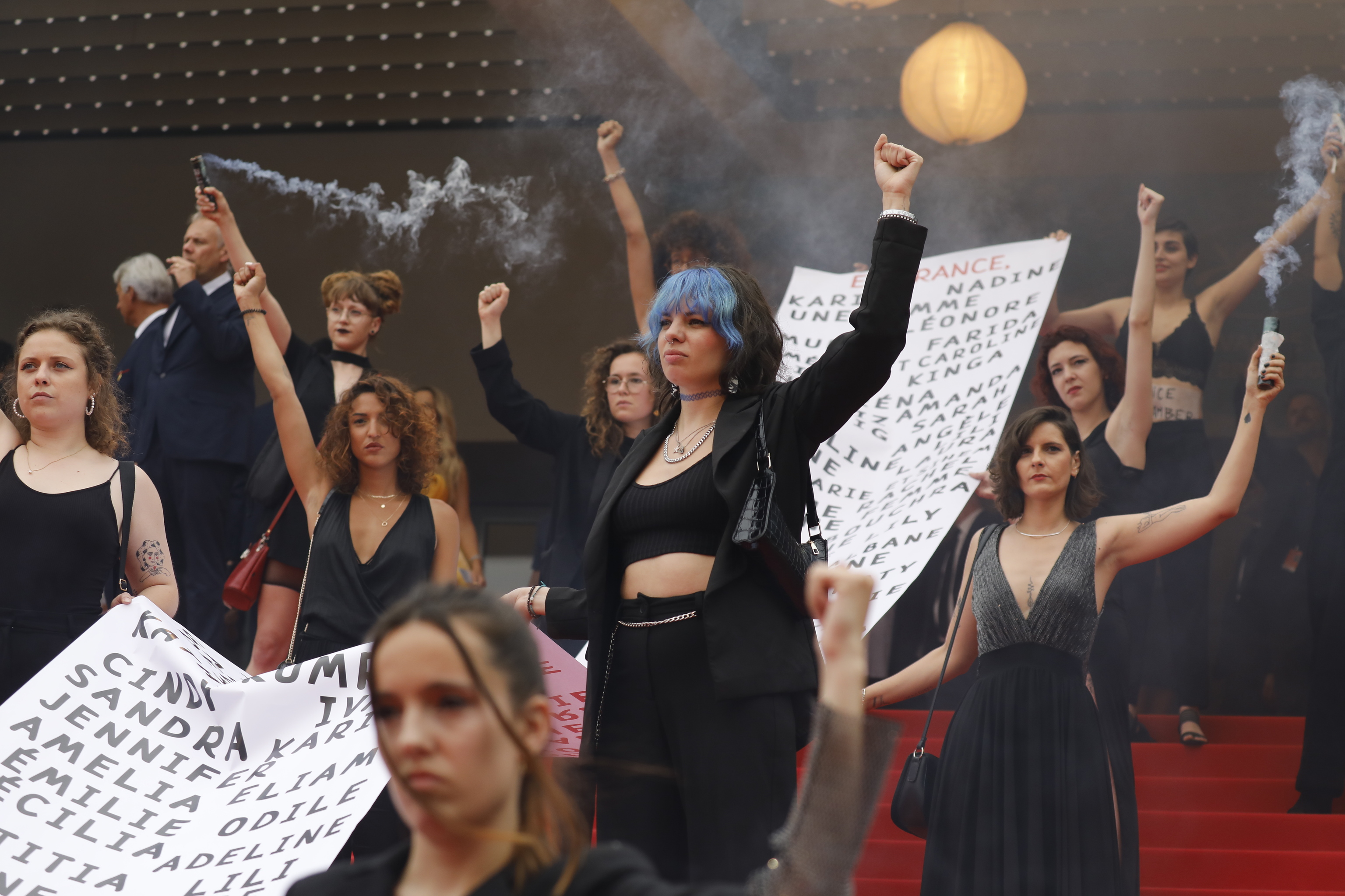 Activistas del movimiento feminista 'Les Colleuses' portan una pancarta con los nombres de las 129 mujeres asesinadas por la violencia machista en Francia en la presentación de 'Holy spider' en Cannes.