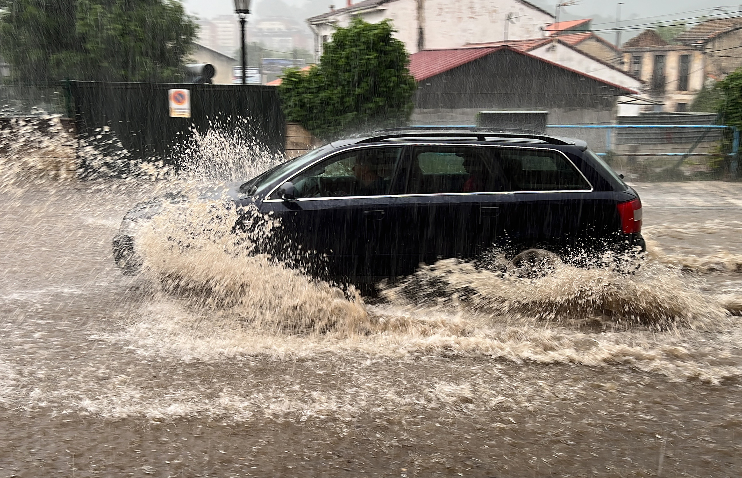Un coche circulando en mitad de la tormenta en Oviedo