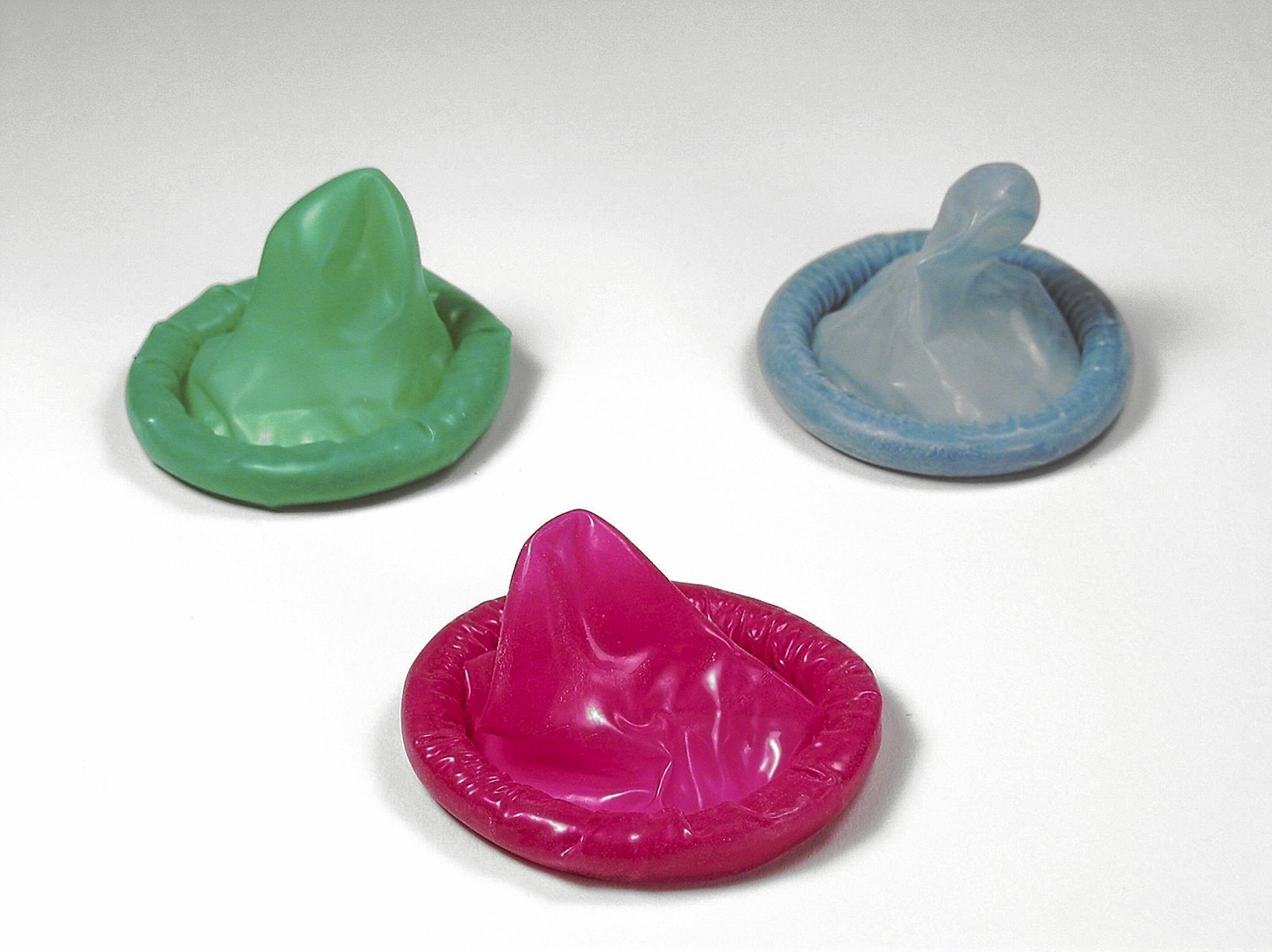 Tres preservativos de colores.