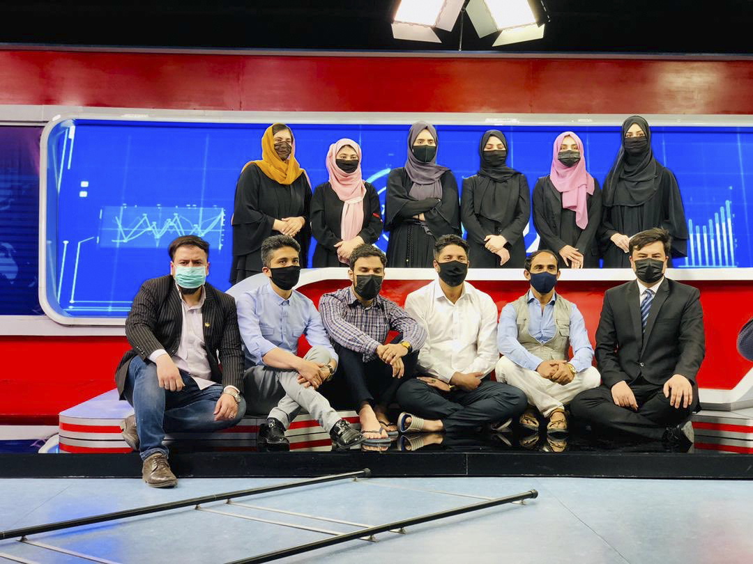 Many journalists of Tolo News pose with their faces covered.