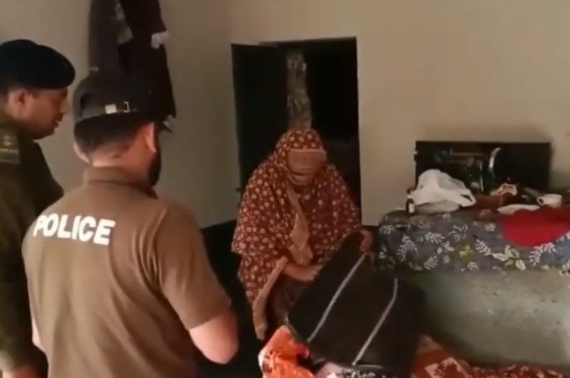 Azra Bibi, busca en su maleta su pasaporte ante la policía pakistaní