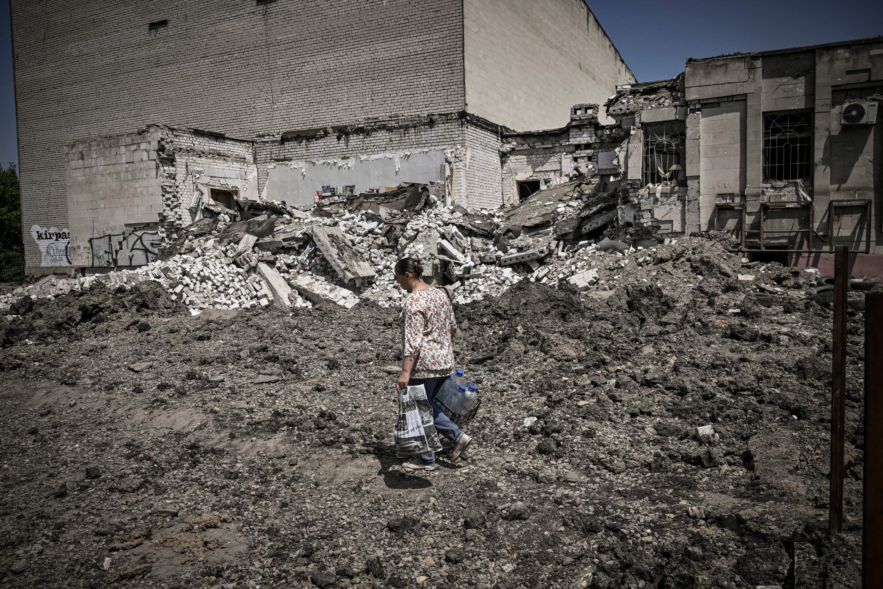 A woman walks past a bombed building in Lysytsansk.