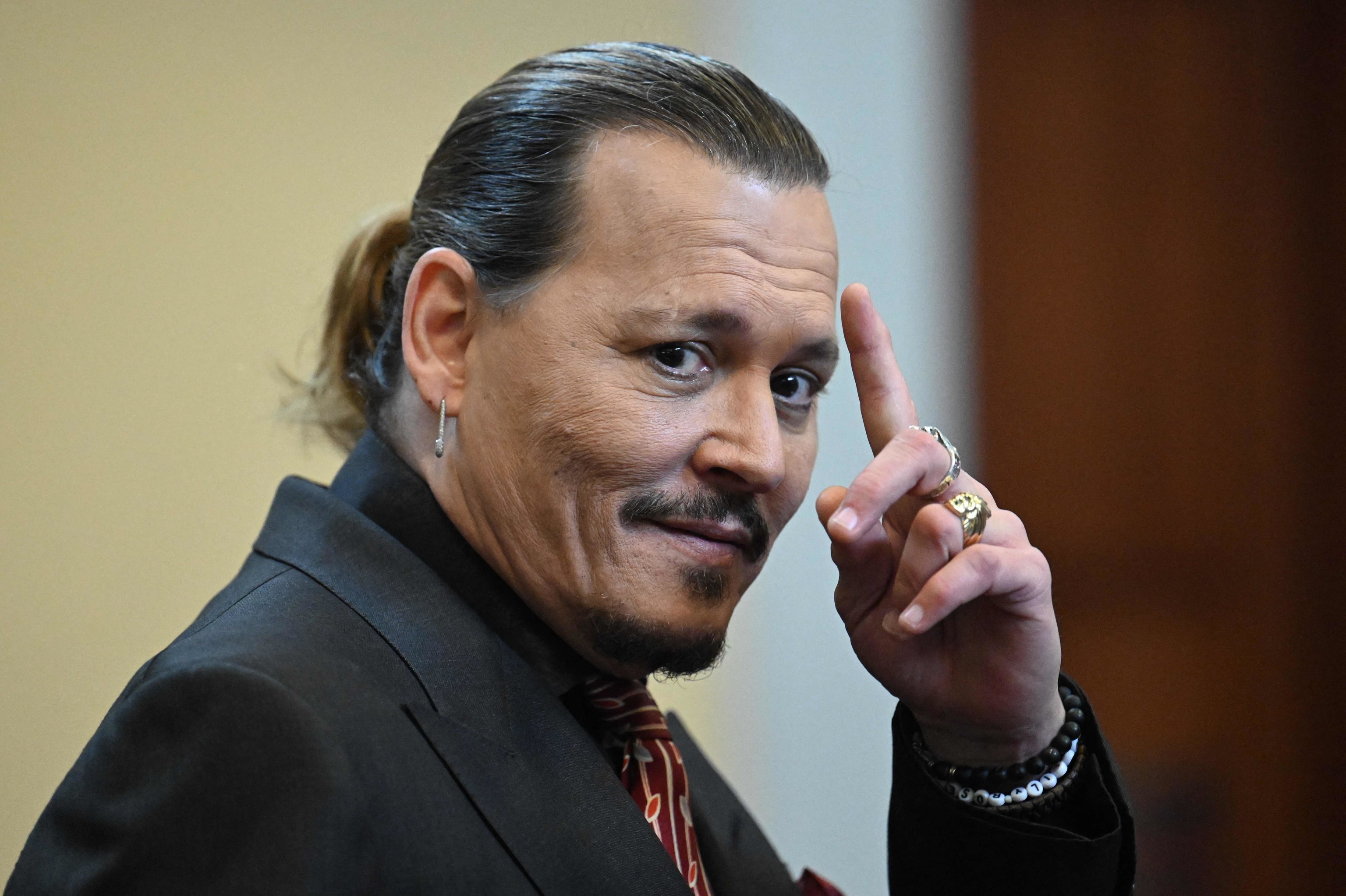 Johnny Depp waves at trial in Fairfax, Virginia.