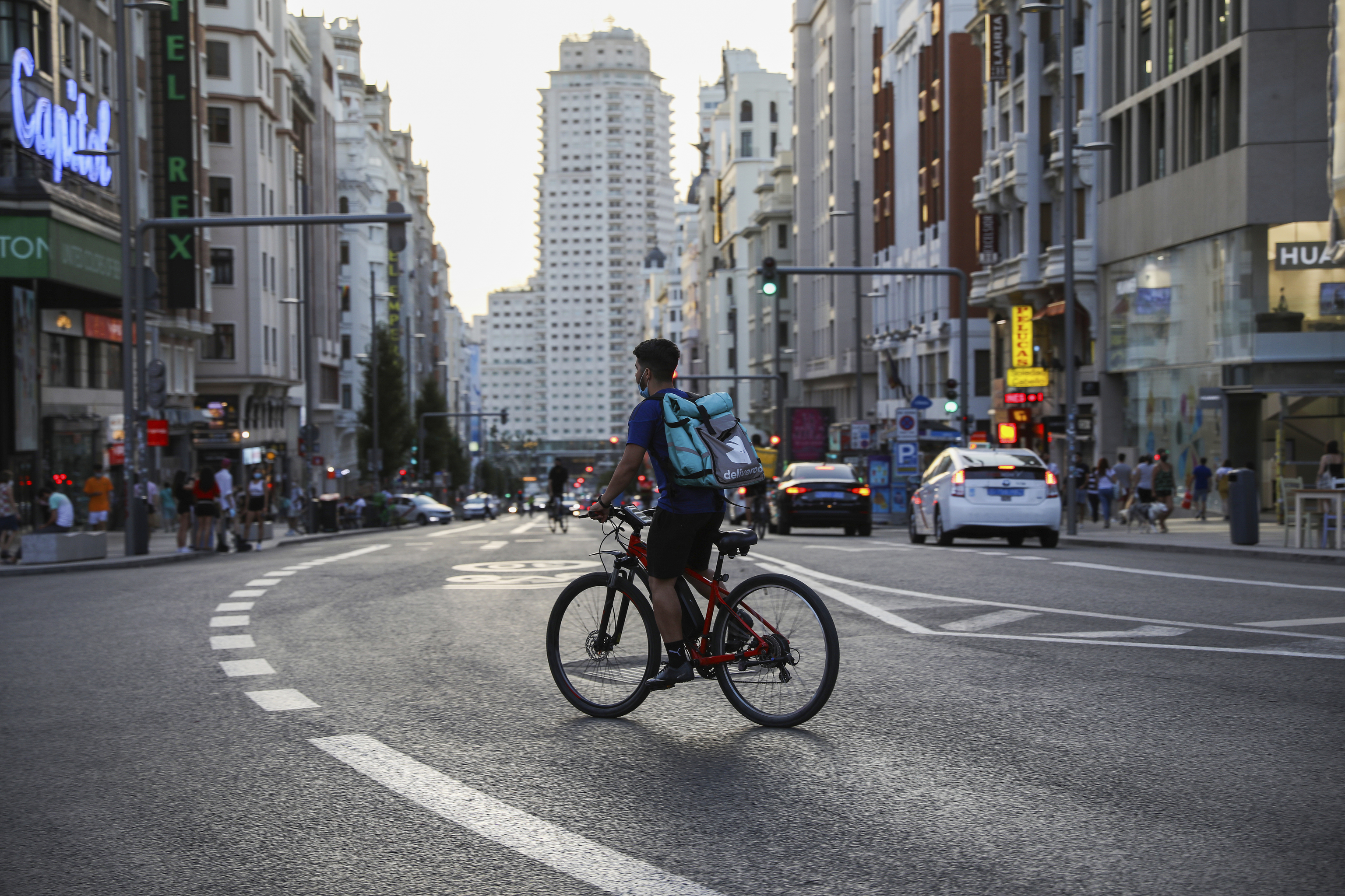 A home delivery cyclist crosses Madrid's Gran Vias