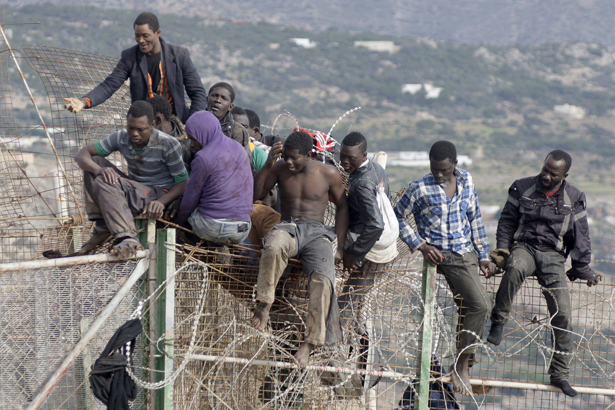 Inmigrantes saltando la valla de Melilla.