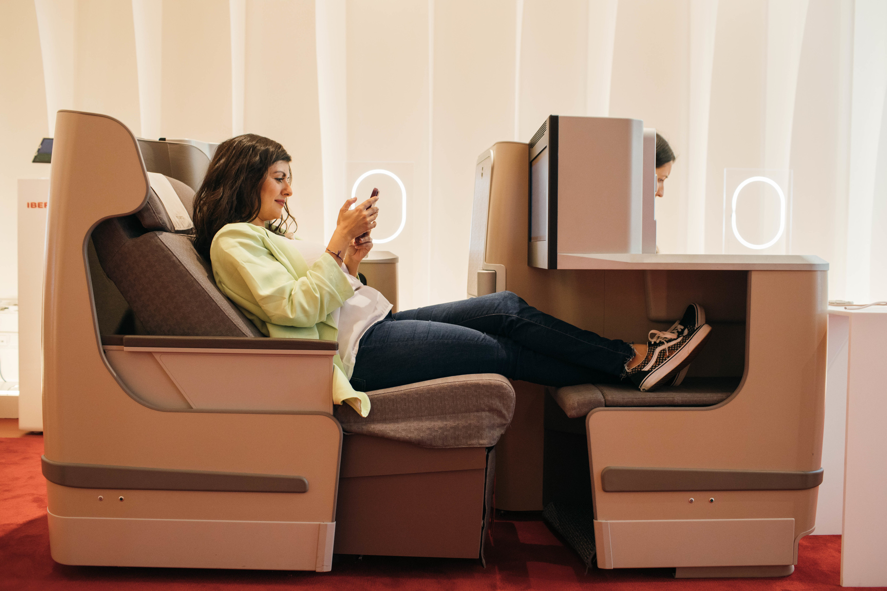 Una mujer se relaja en uno de los sillones de la clase Business que ha recreado la aerolnea en el Espacio Iberia.