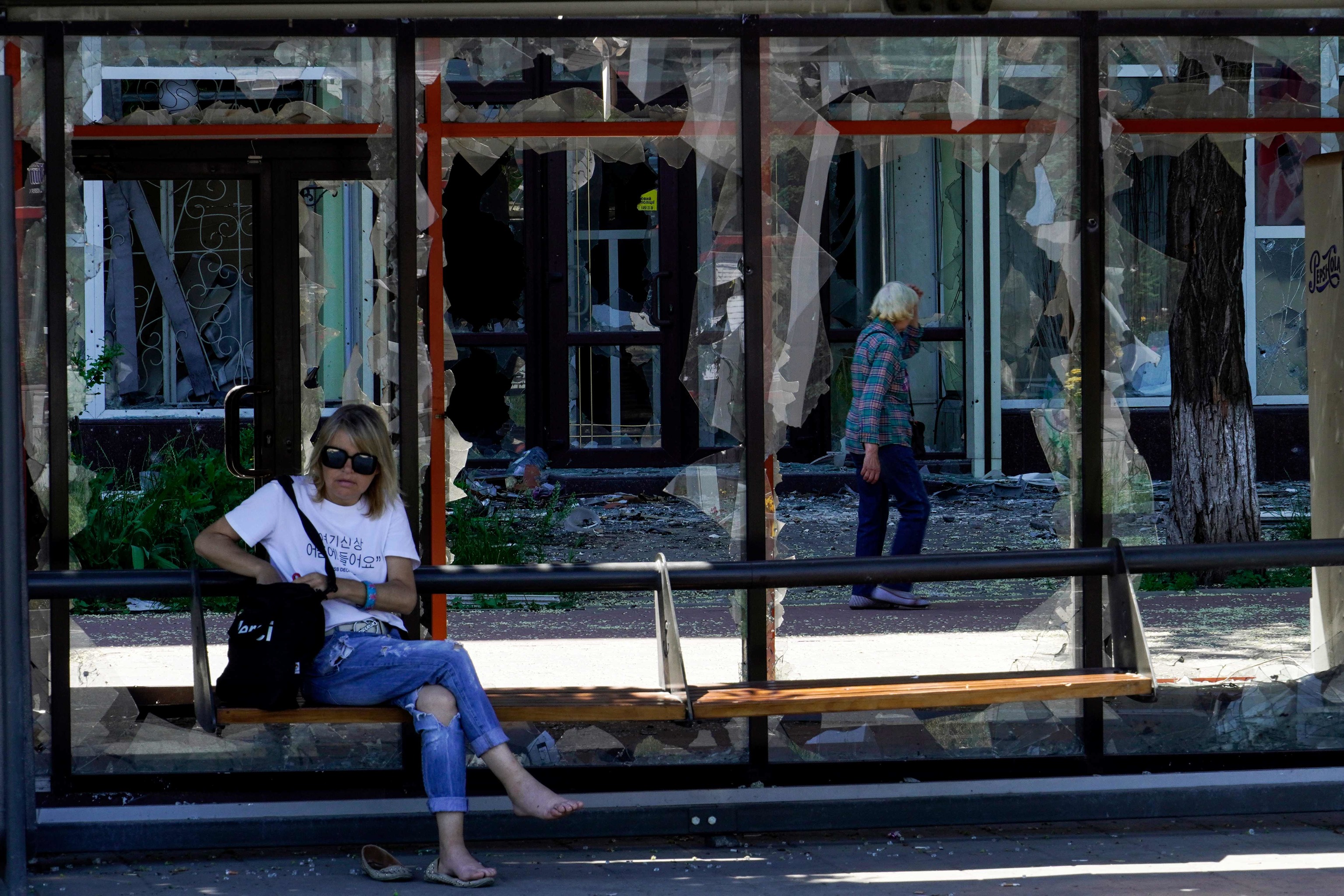 Una mujer, en una parada de Mariupol destruida. AFP