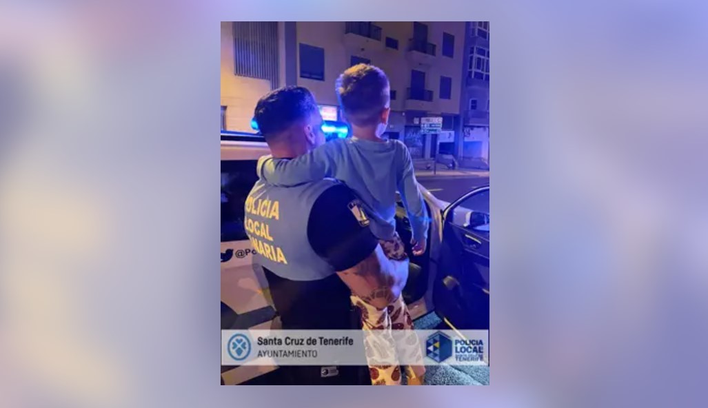 Un agente de la Polica Local de Santa Cruz de Tenerife sostiene en brazos al nio que fue encontrado deambulando solo y en pijama por la calle San Sebastin