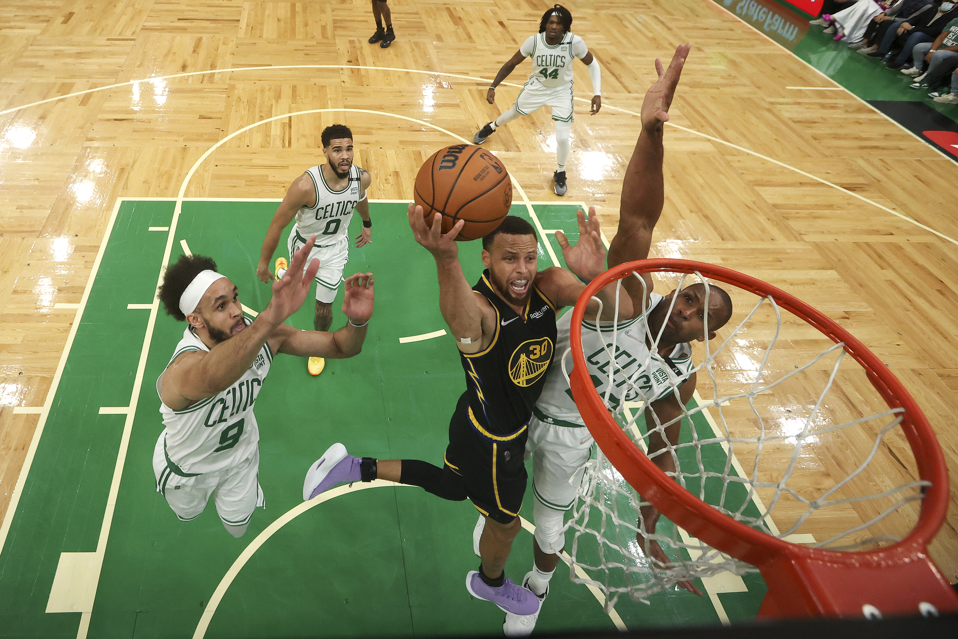 El escolta de los Golden State Warriors Stephen Curry (30) sube a por un tiro contra el pvot de los Boston Celtics Al Horford (42) y el escolta Derrick White (9) durante el cuarto partido de las Finales de la NBA de baloncesto, el viernes 10 de junio de 2022, en Boston