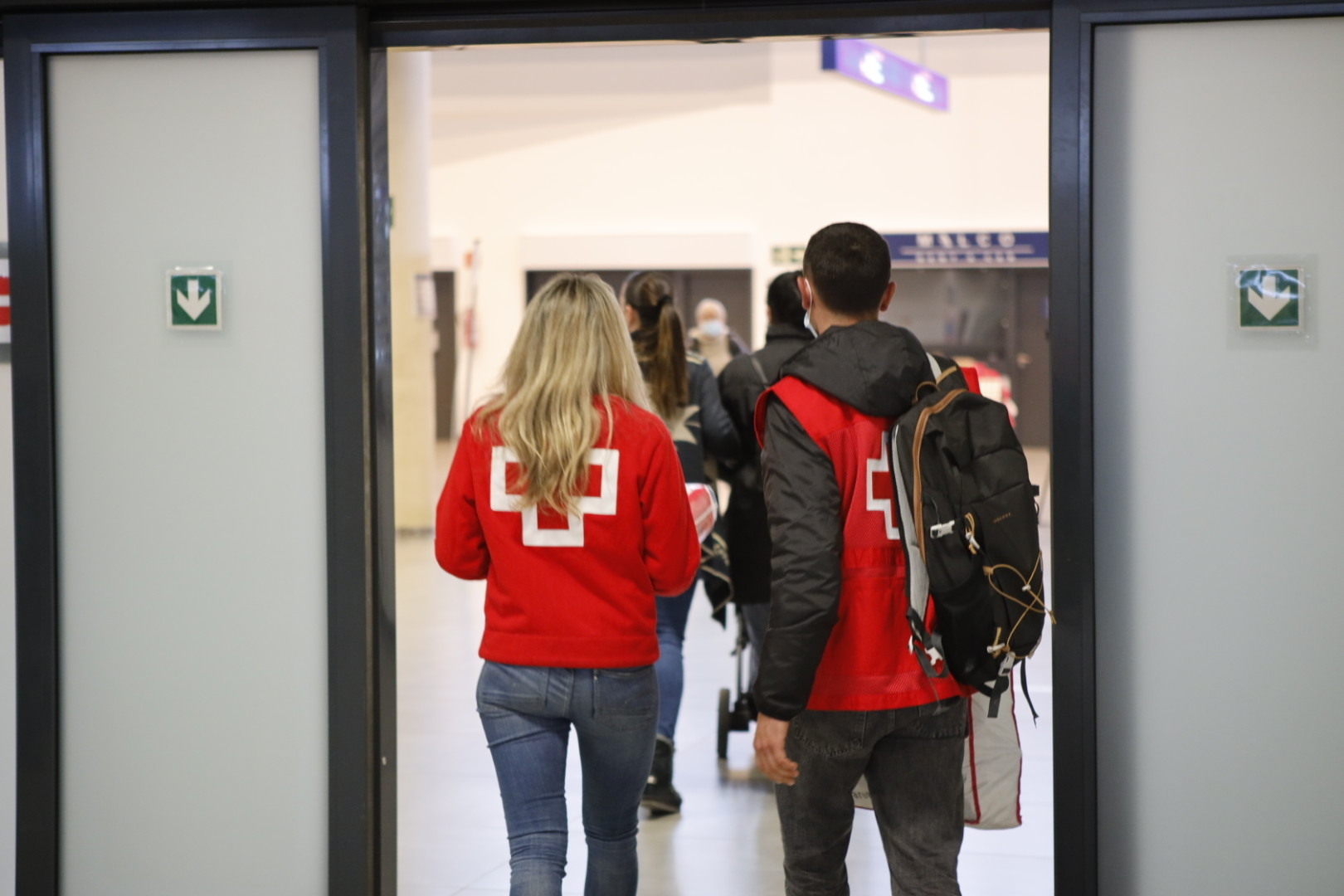 Voluntarios de Cruz Roja reciben a los refugiados en el aeropuerto.