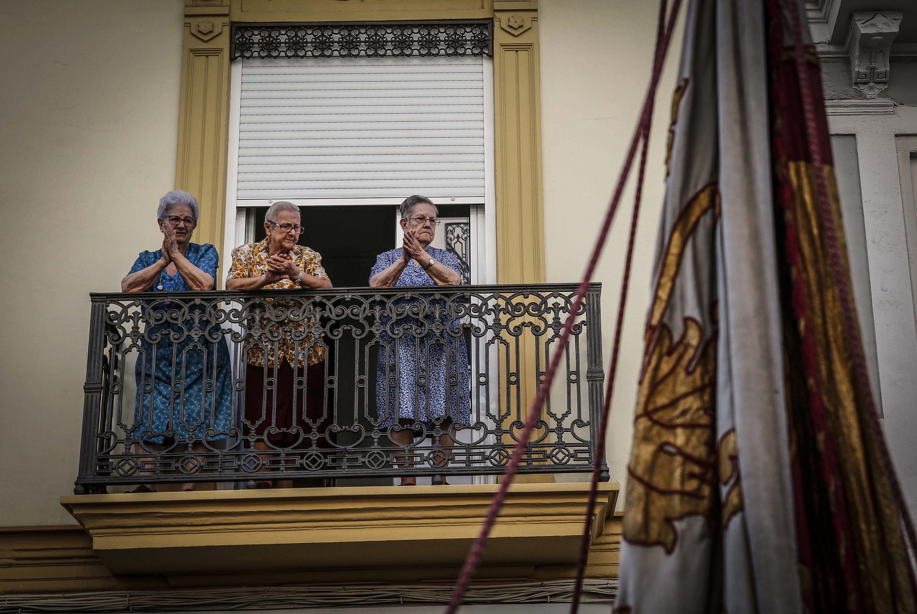 Una ancianas aplauden desde el balcn.