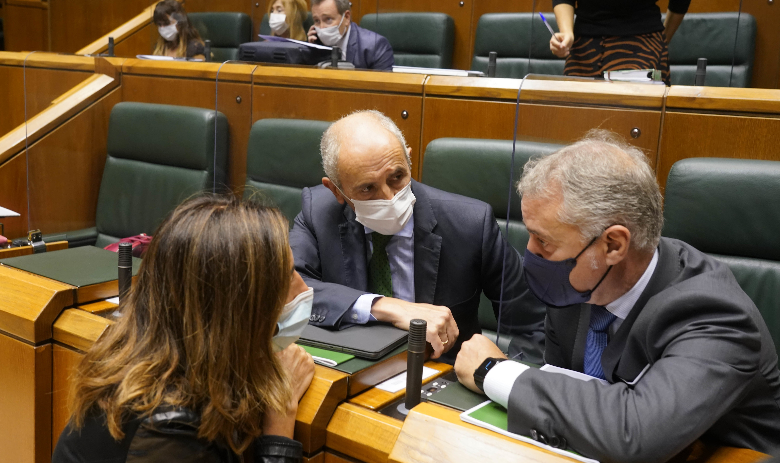 Erkoreka y Urkullu conversan desde su escao con la consejera Olatz Garamendi durante un pleno del Parlamento Vasco.