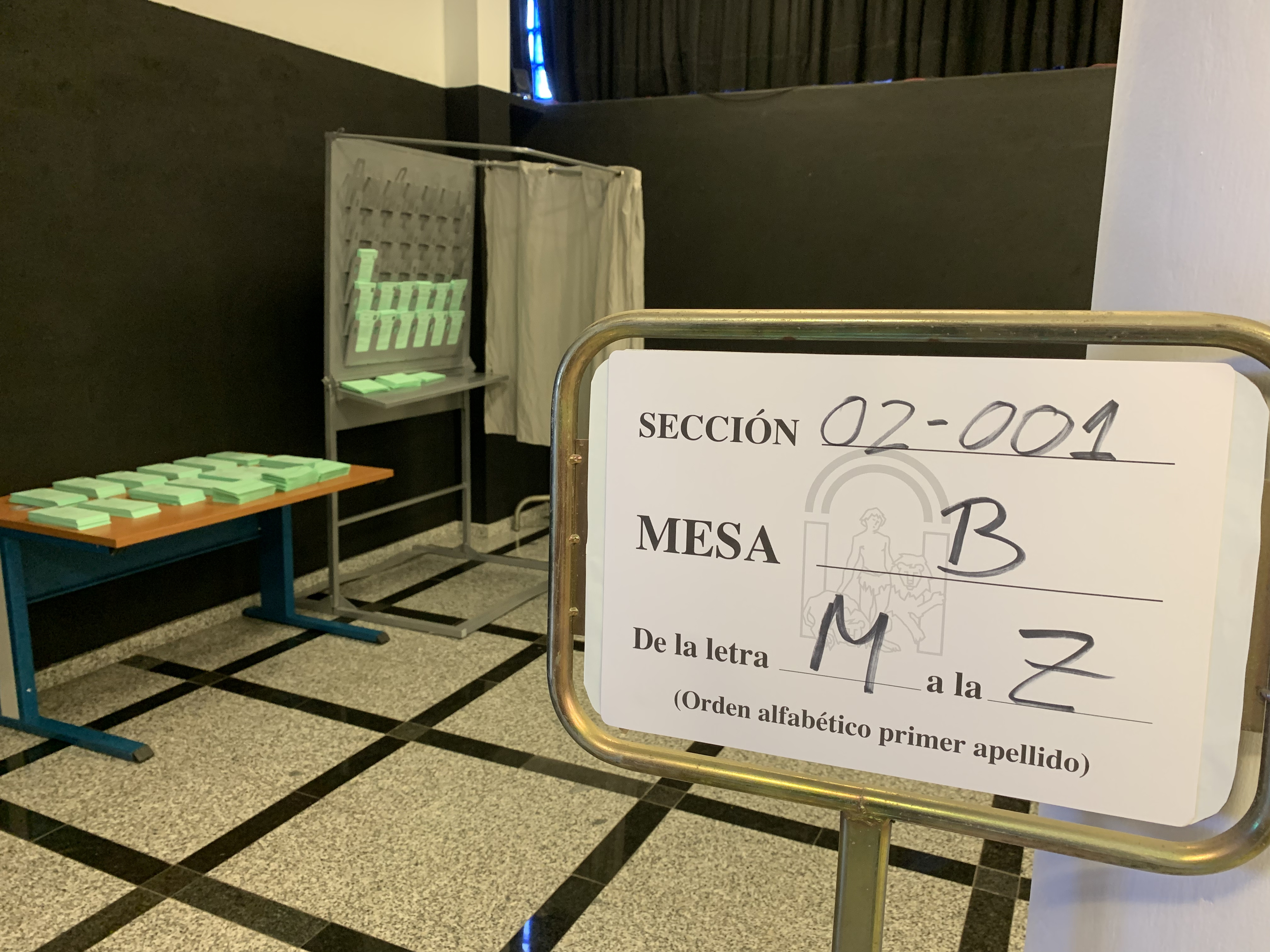 Stand y mesa con las papeletas que ya han sido dispuestas en un colegio electoral de Sevilla para la votación de este domingo.