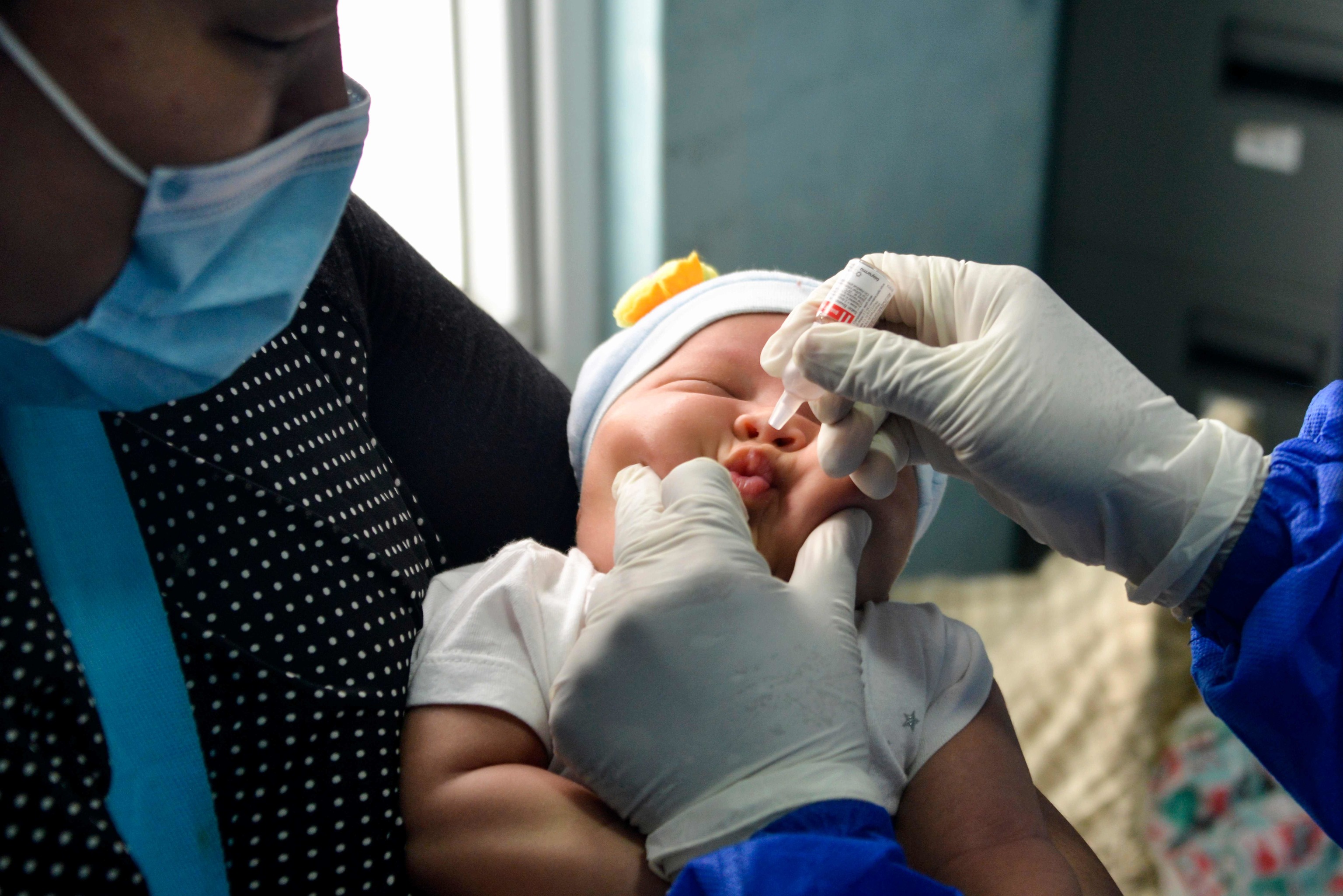 Un bebé recibe la vacuna oral de la polio.